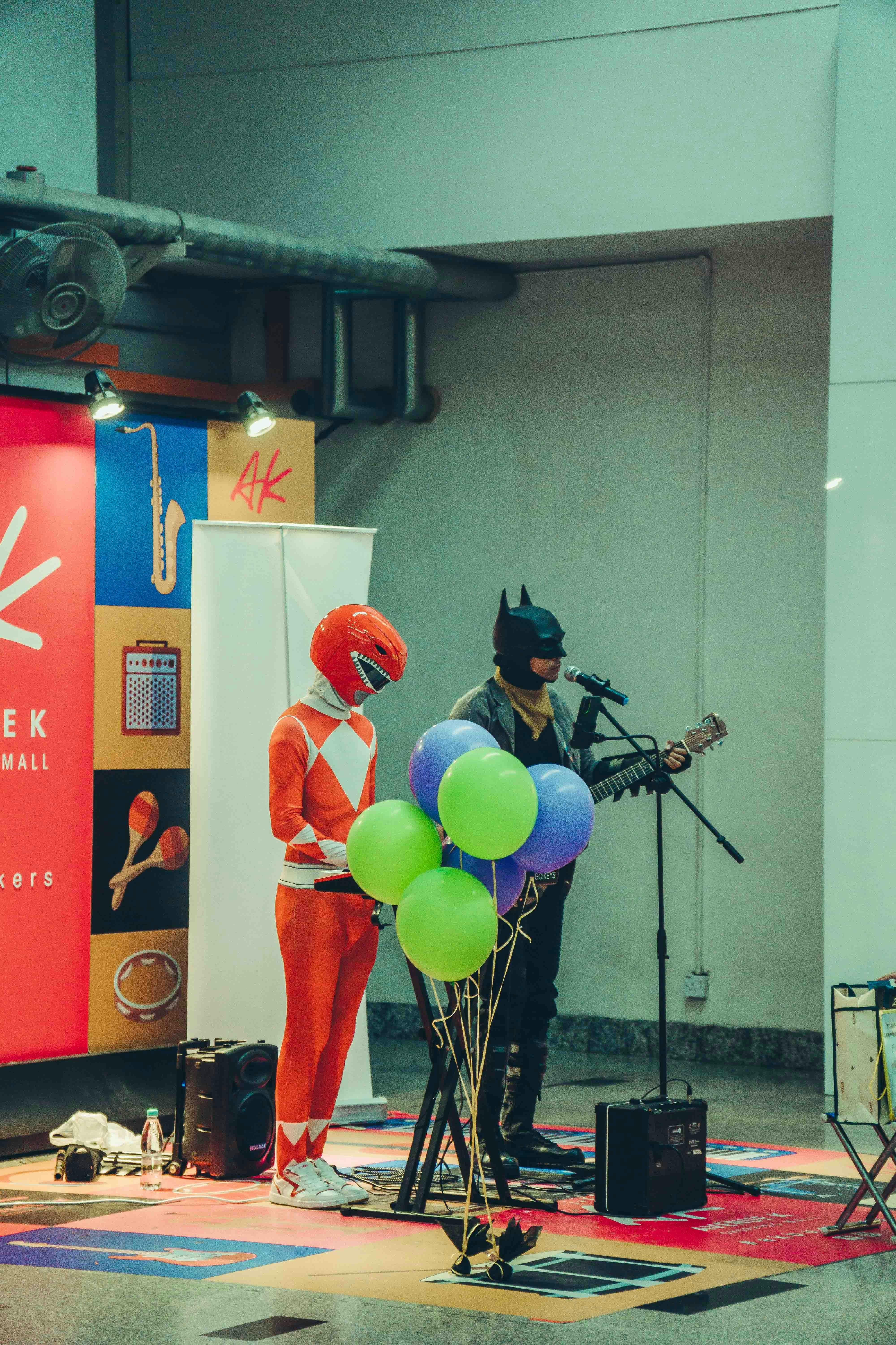 Batman dan seorang power ranger sedang menampilkan musik.