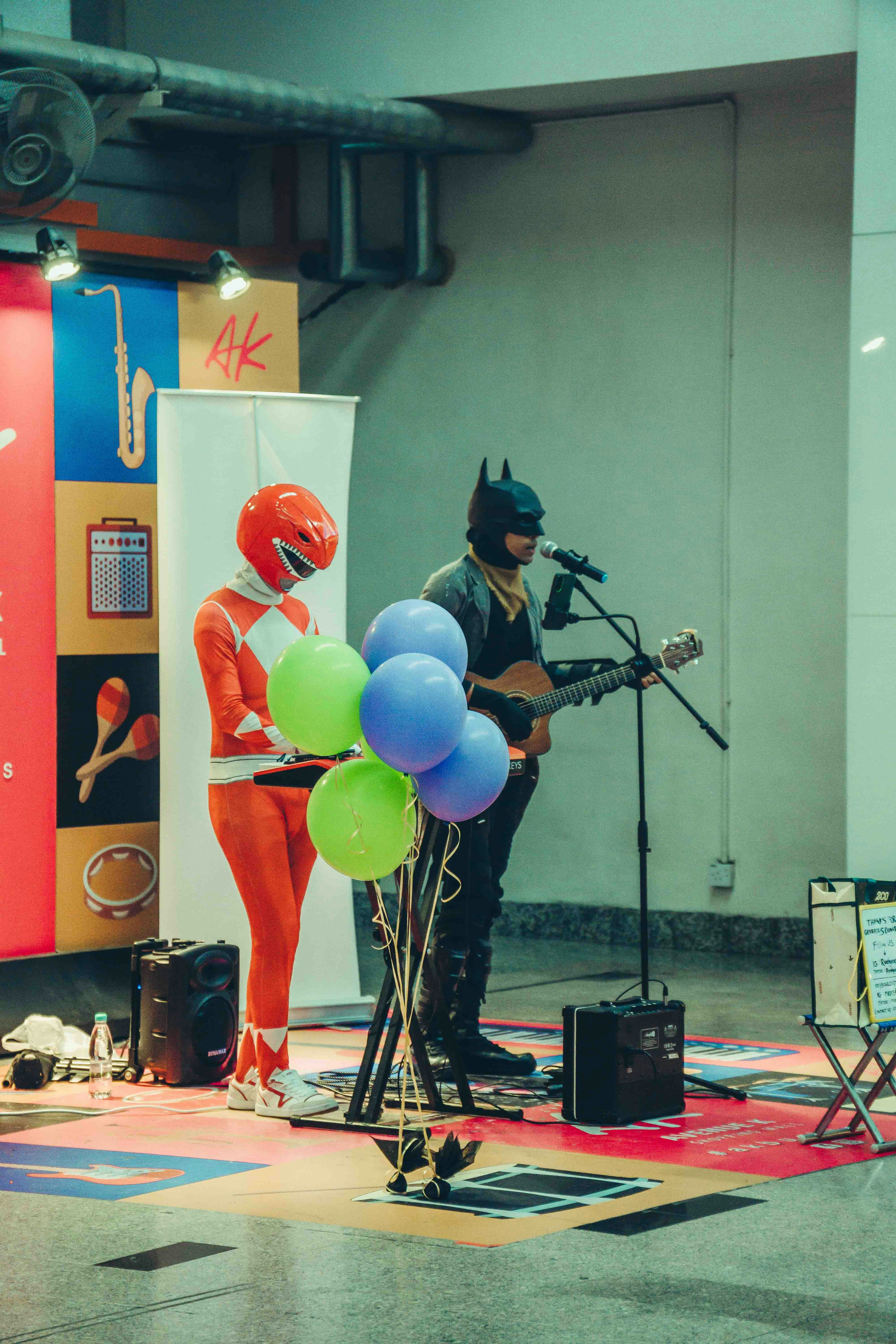 Batman dan penjaga merah tampil dengan gitar.