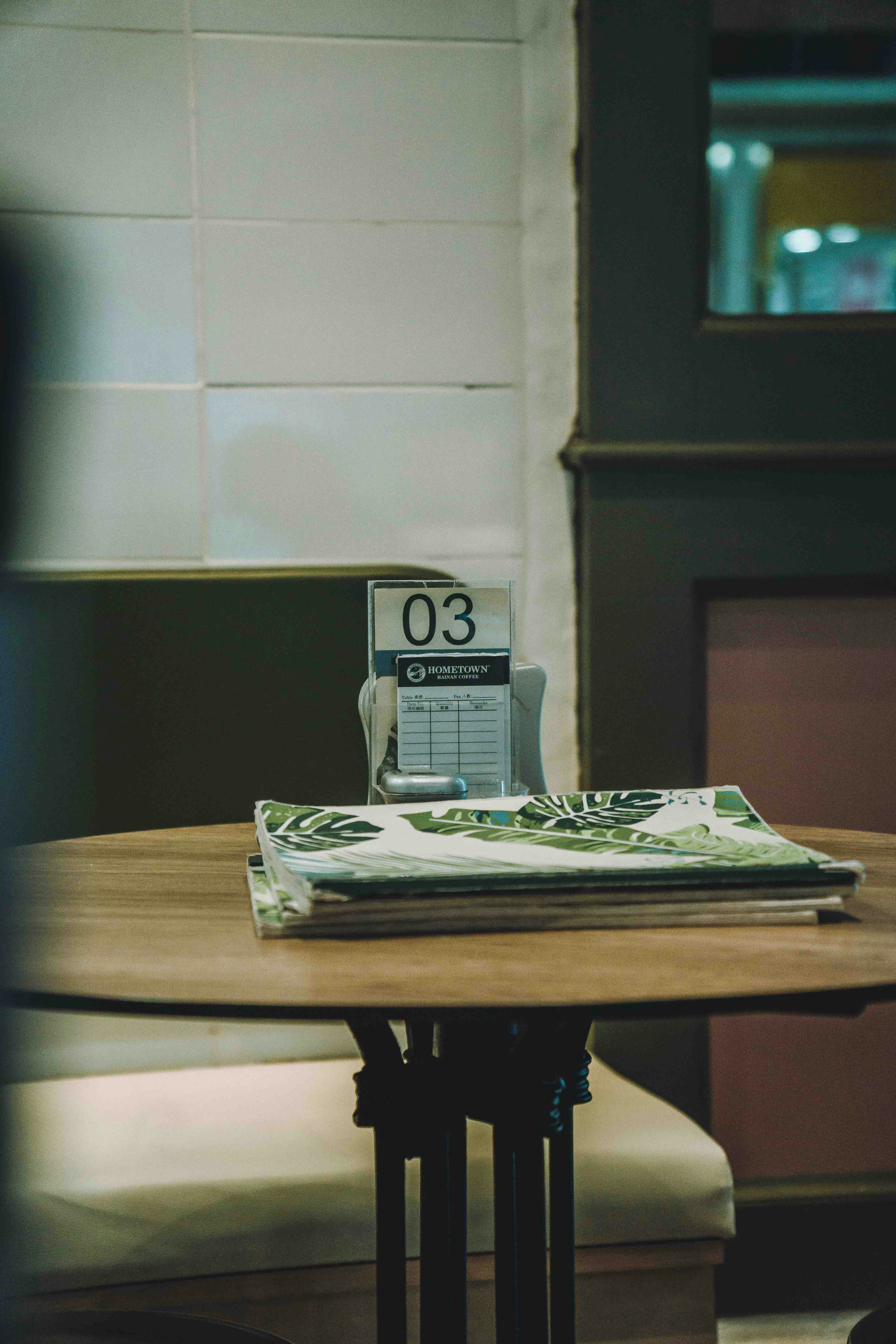 Una mesa en una cafetería con menú y número.
