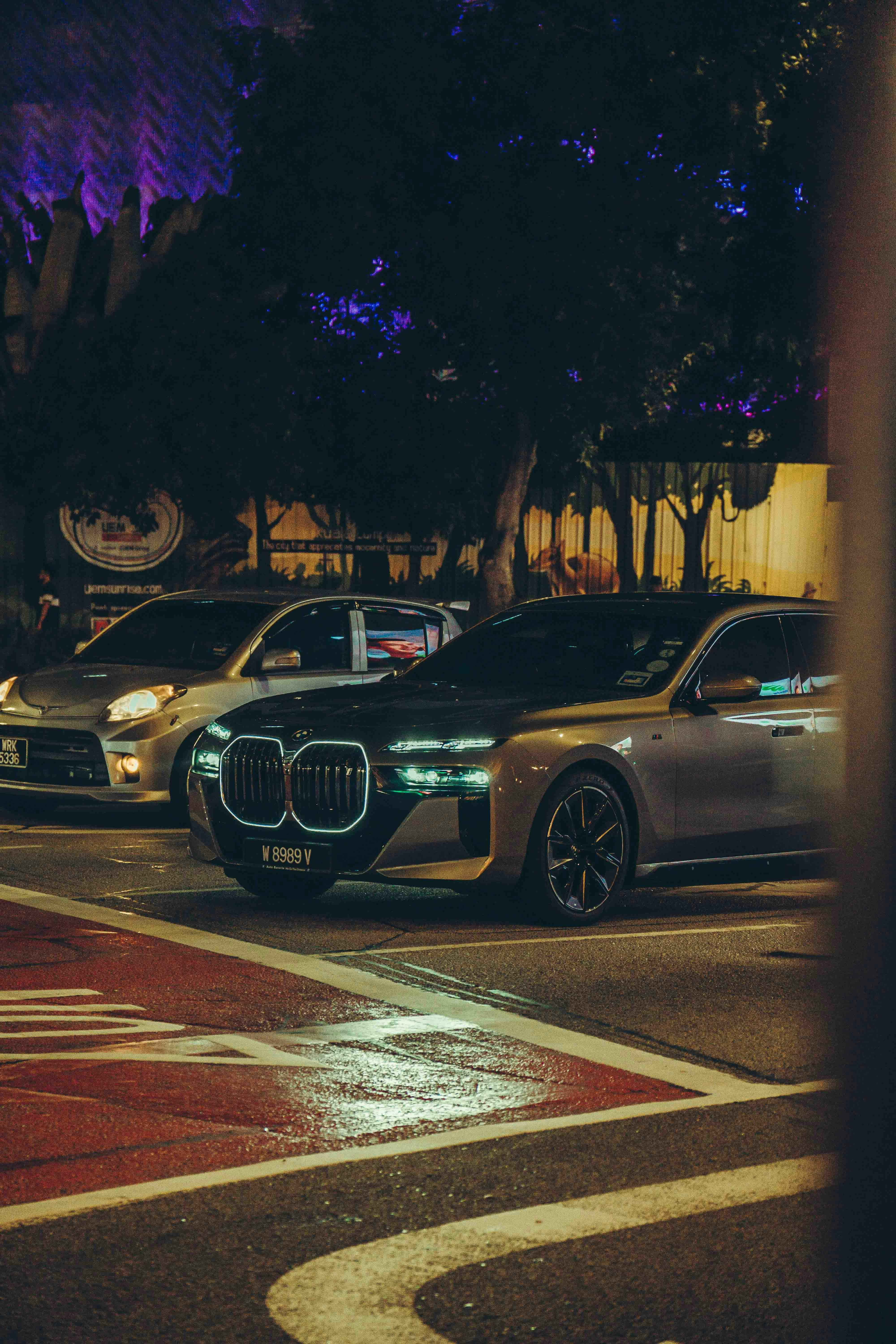 Coches de lujo aparcados en una calle de la ciudad por la noche.