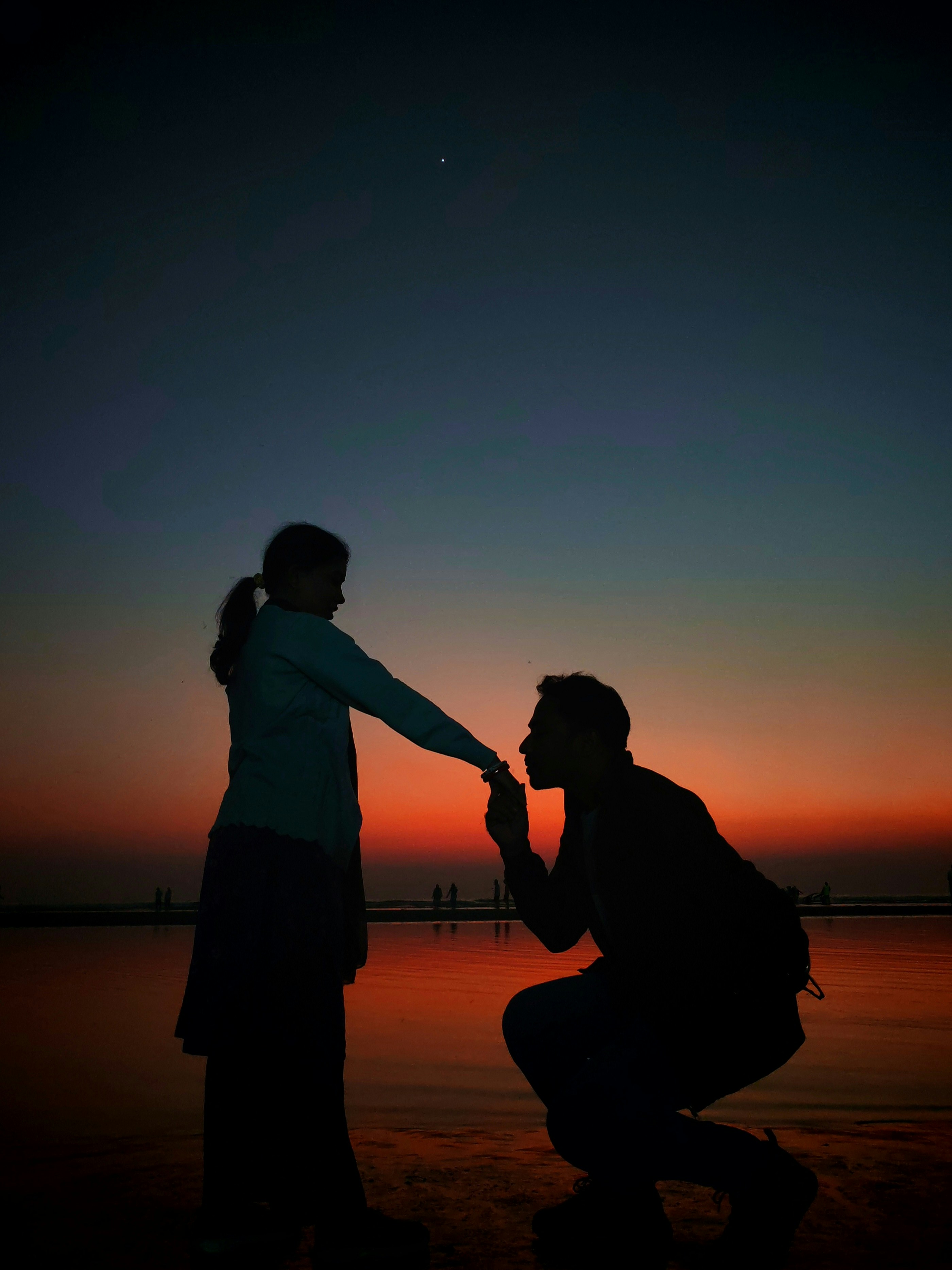 He's proposing to her during a beautiful sunset