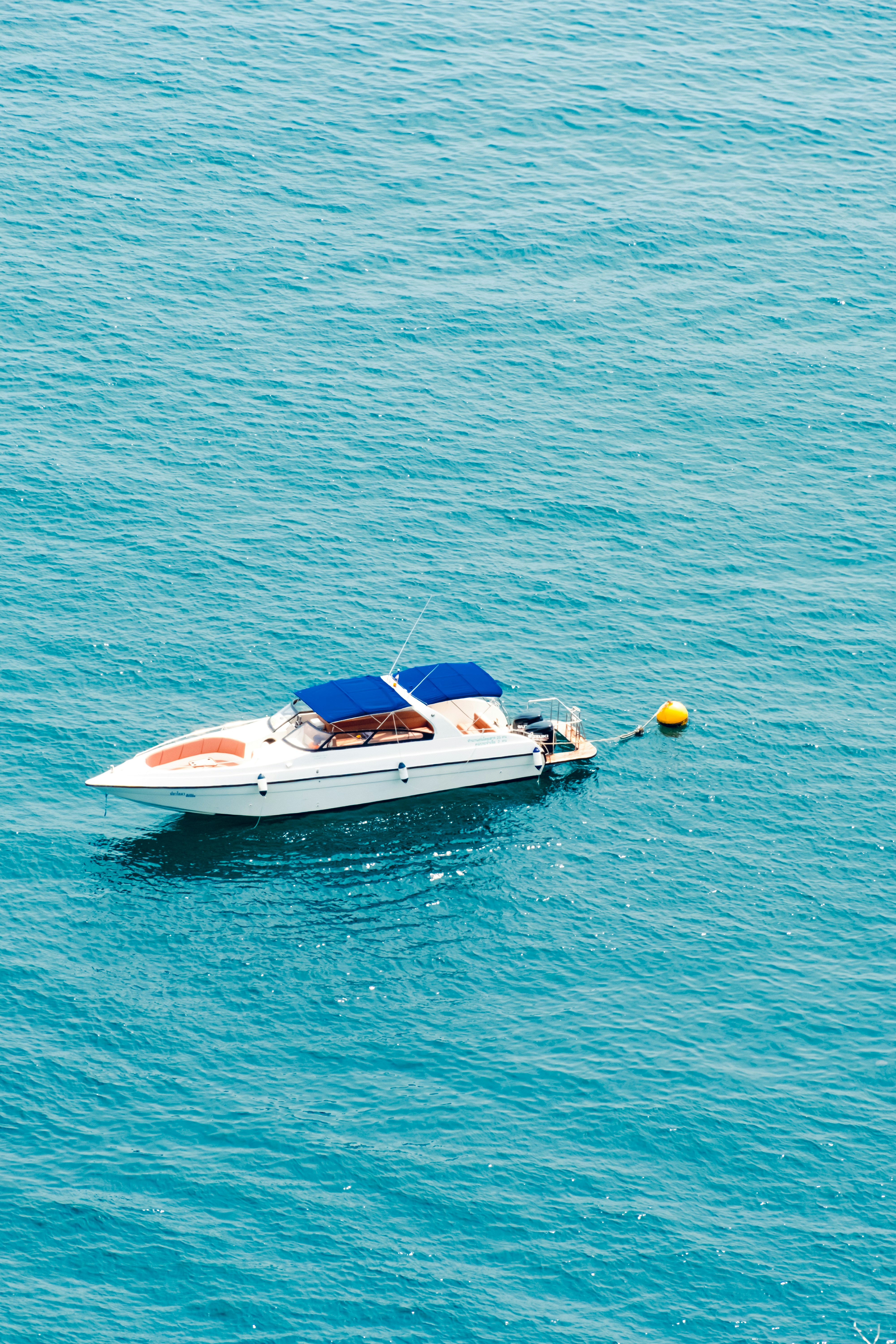A boat floats on the blue ocean.