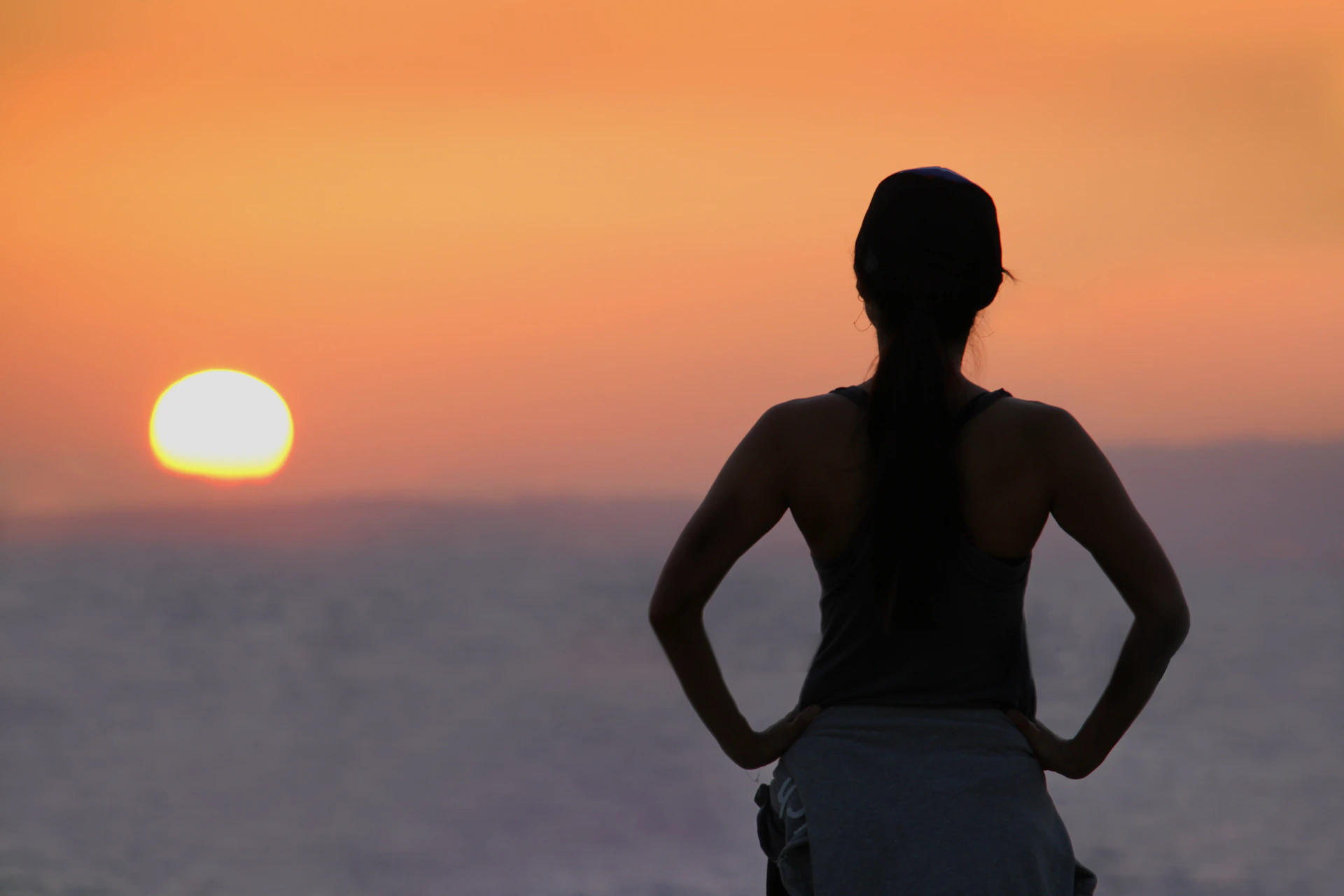 Woman watches the sunset over the ocean.