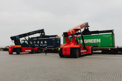 Forklifts unload cargo containers from trains.