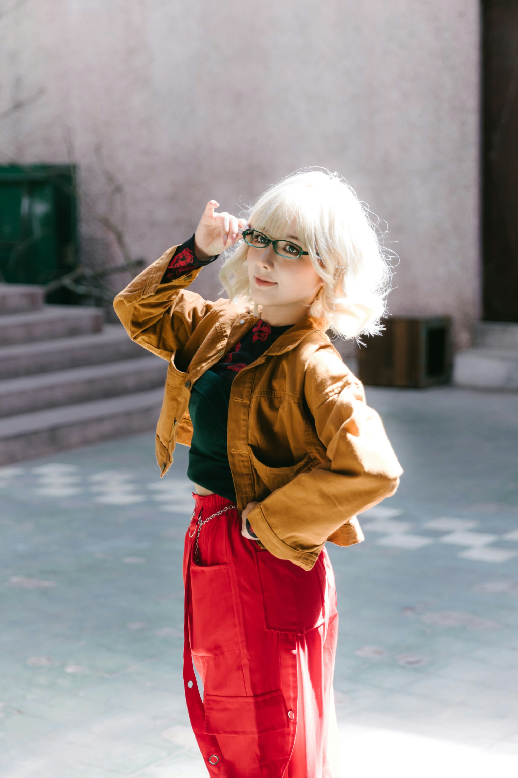 A woman with stylish glasses poses outside.