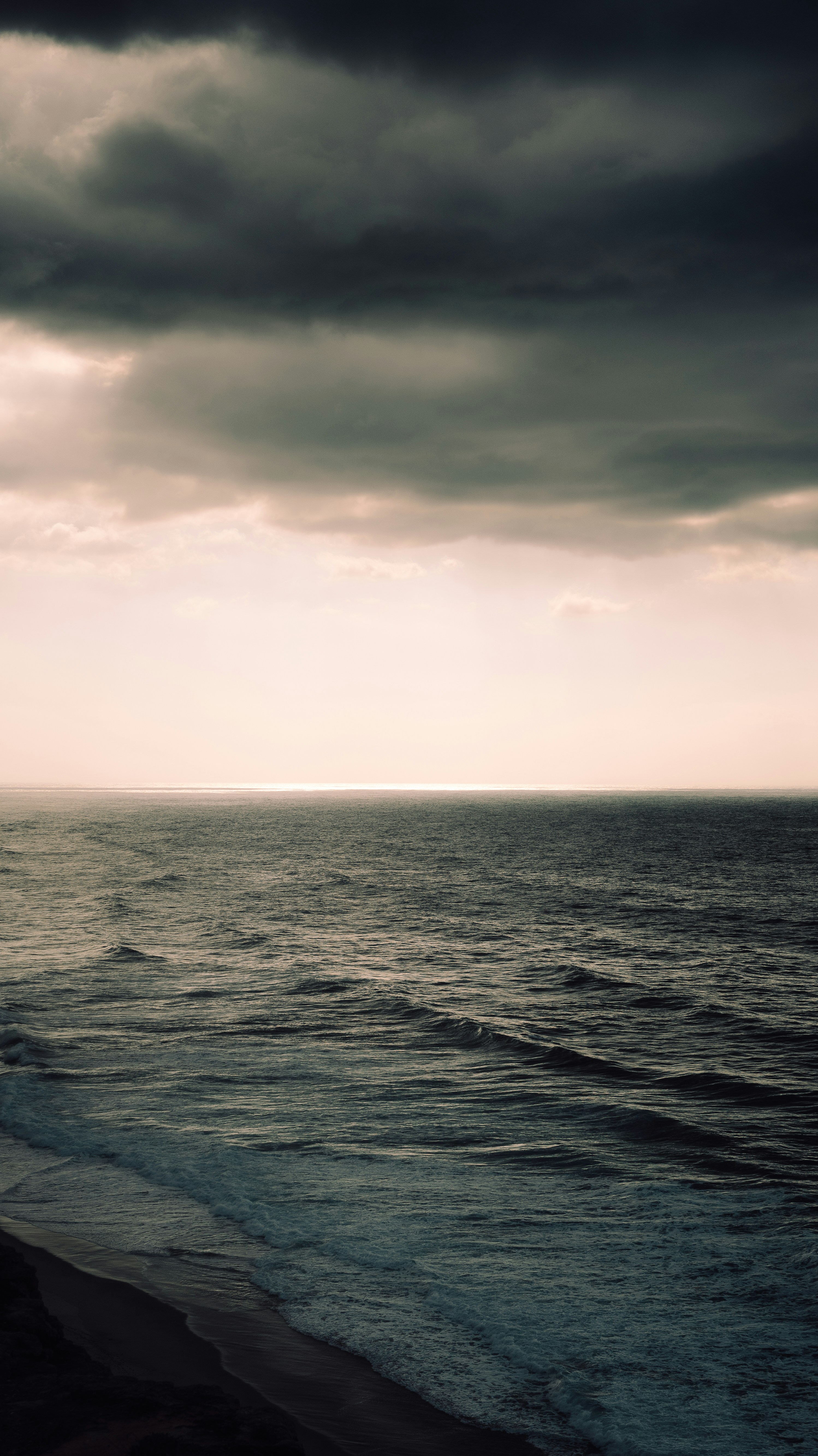 Dark, stormy clouds loom over the turbulent ocean. photo – Free Sunset  Image on Unsplash, image size:3000x5337