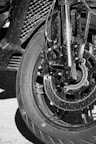 Motorcycle wheel and front suspension in black and white.
