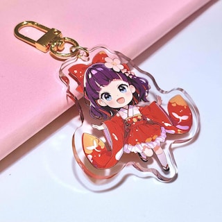 A cute anime girl keychain is shown.