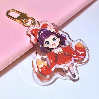 A cute anime girl keychain is shown.