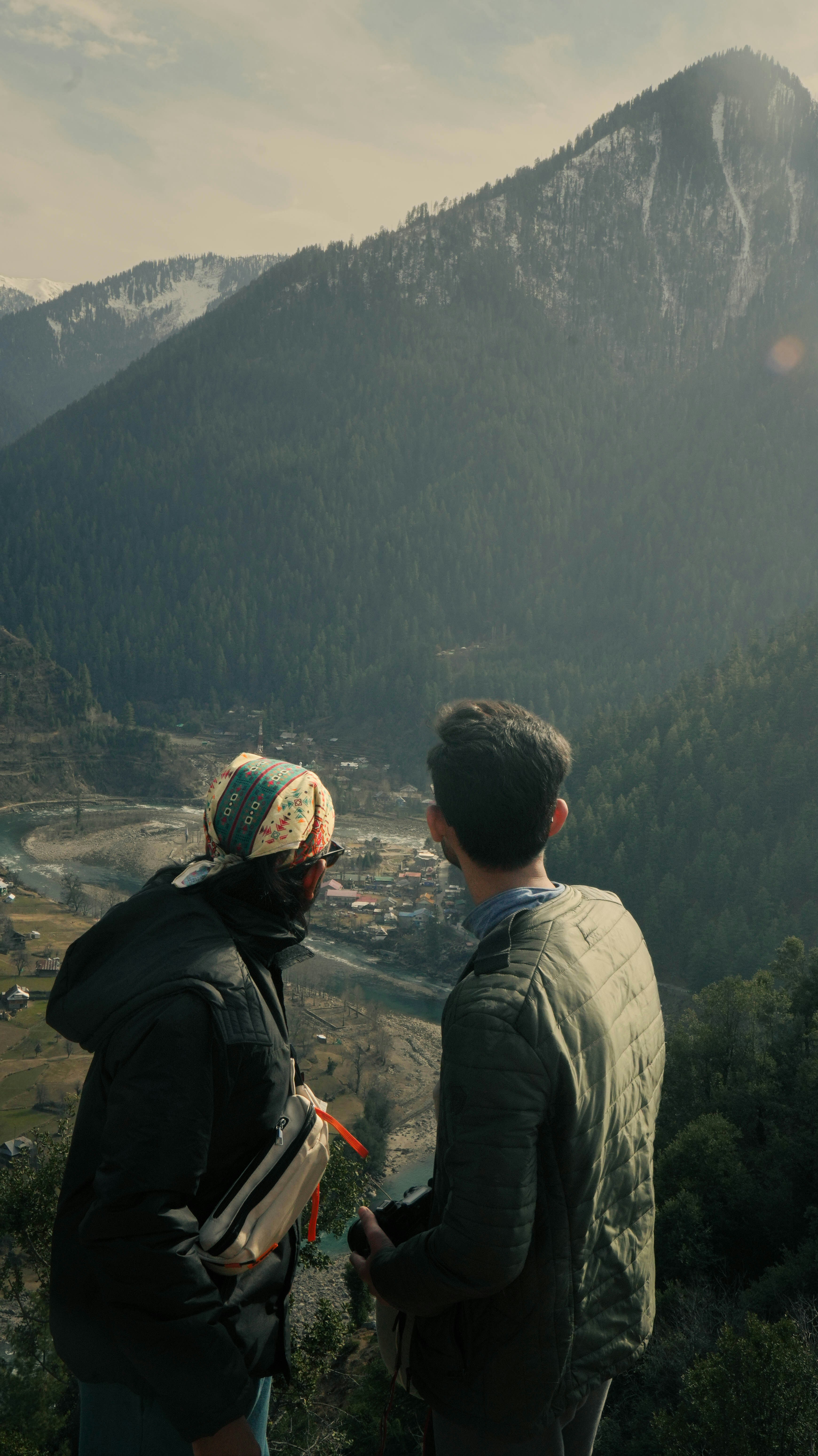 Two people admire the view of the mountains.