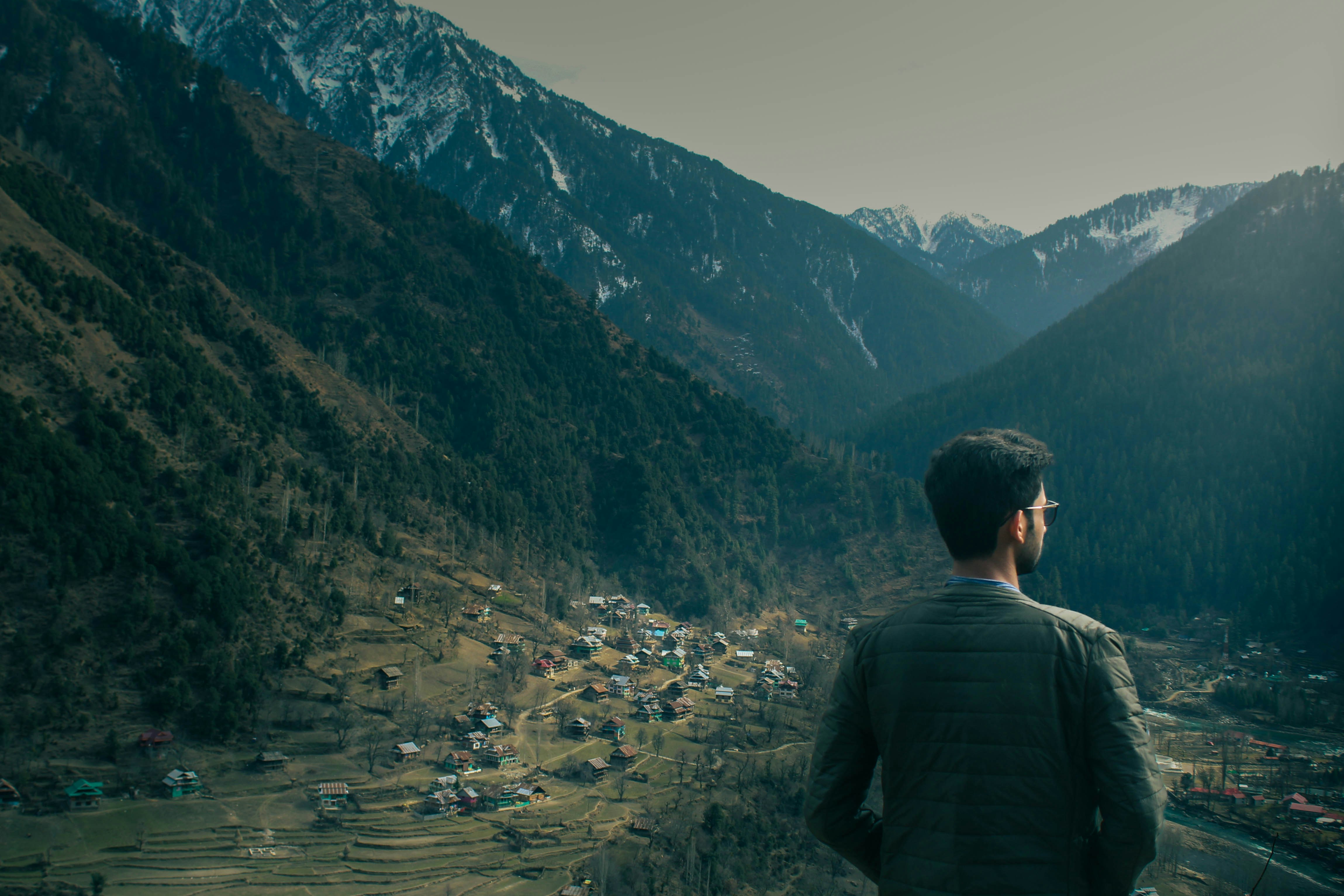 Man gazing at a vast mountain landscape.