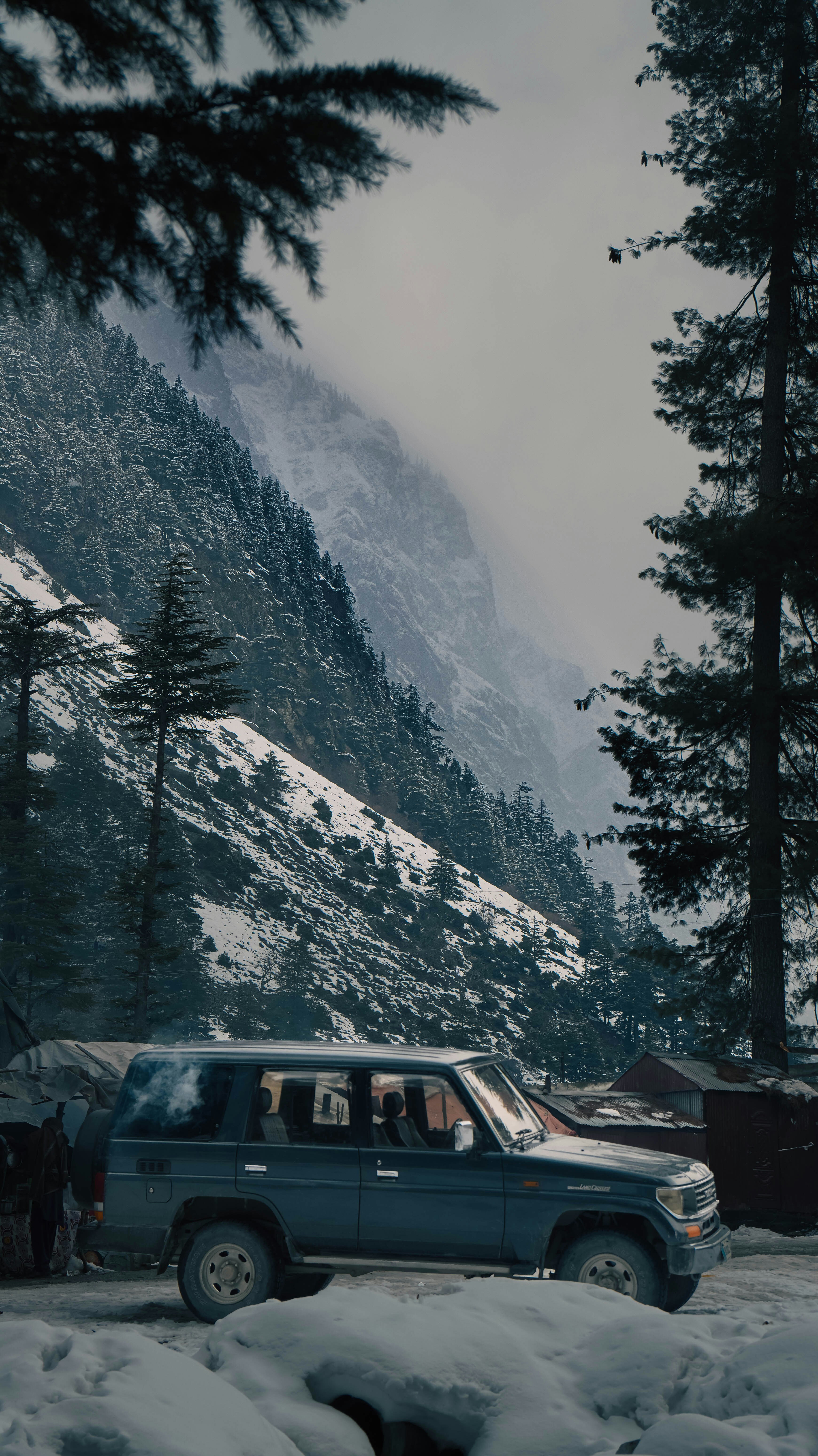Car parked on a snowy mountain road.