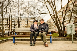 Elderly couple happily sitting on a bench together.