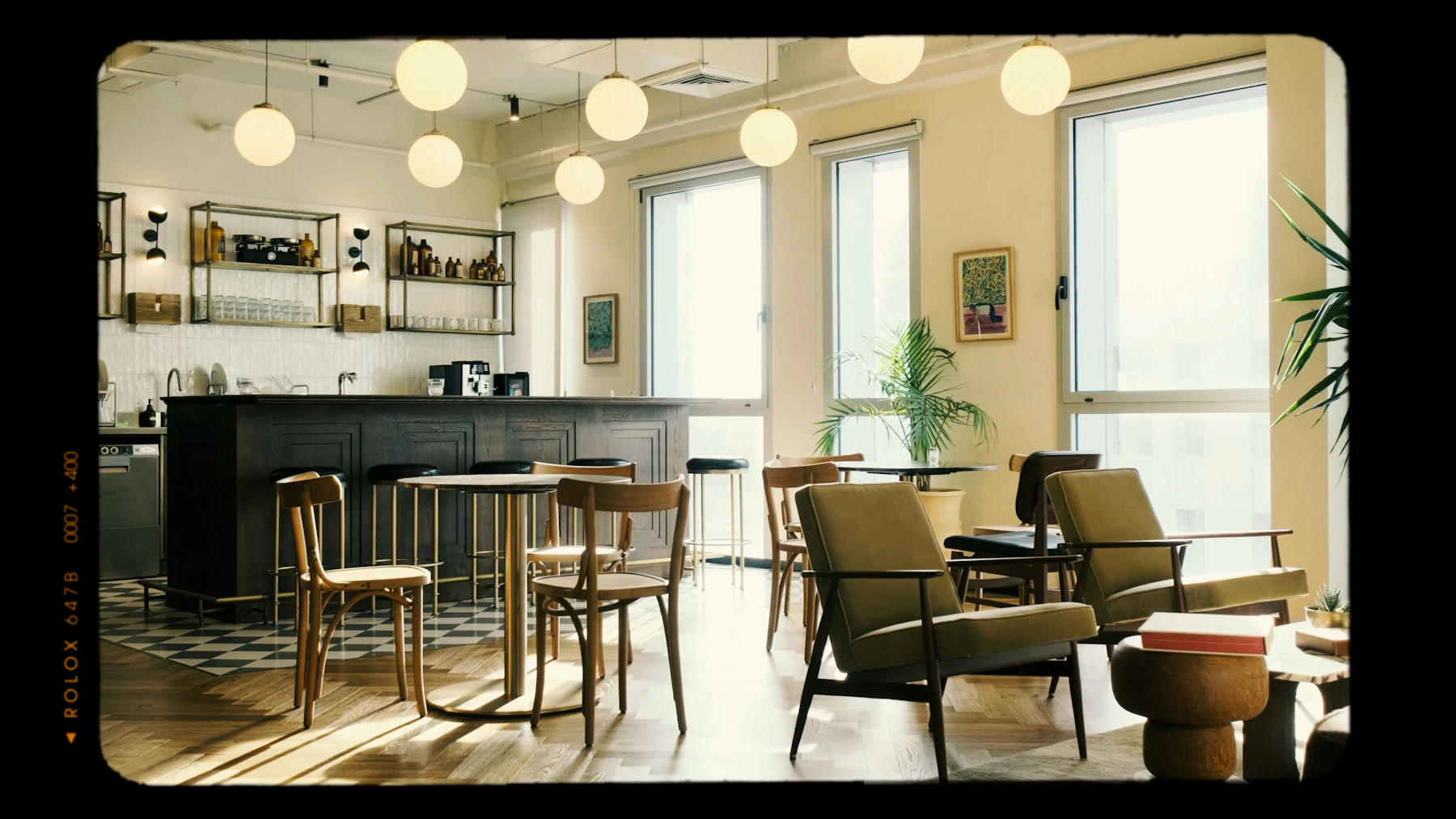 Warm, cozy interior of an independent coffee shop with wood tables and green accents