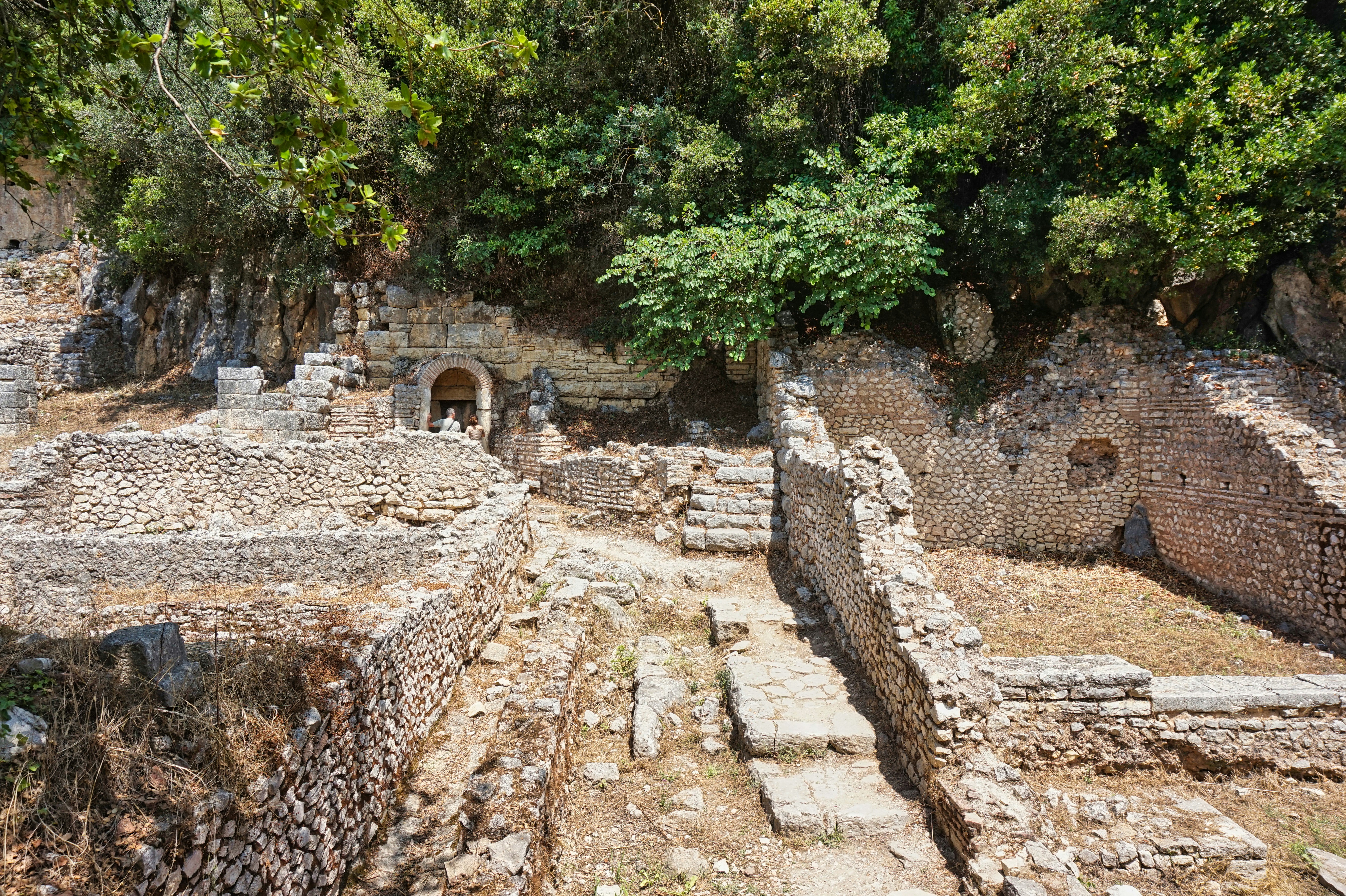Ruined stone structures are partially covered with vegetation.