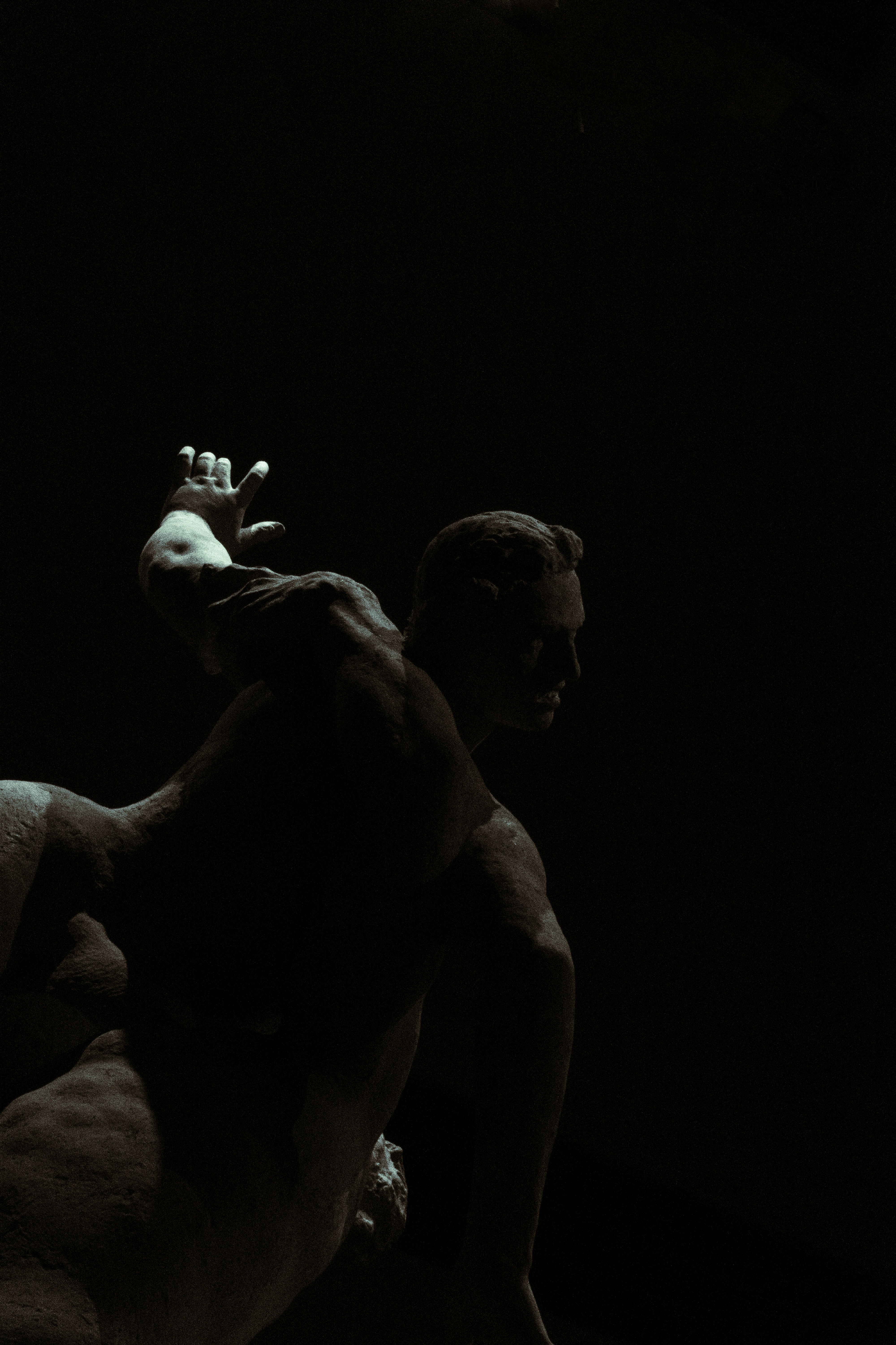 A dramatic statue in a dark setting.