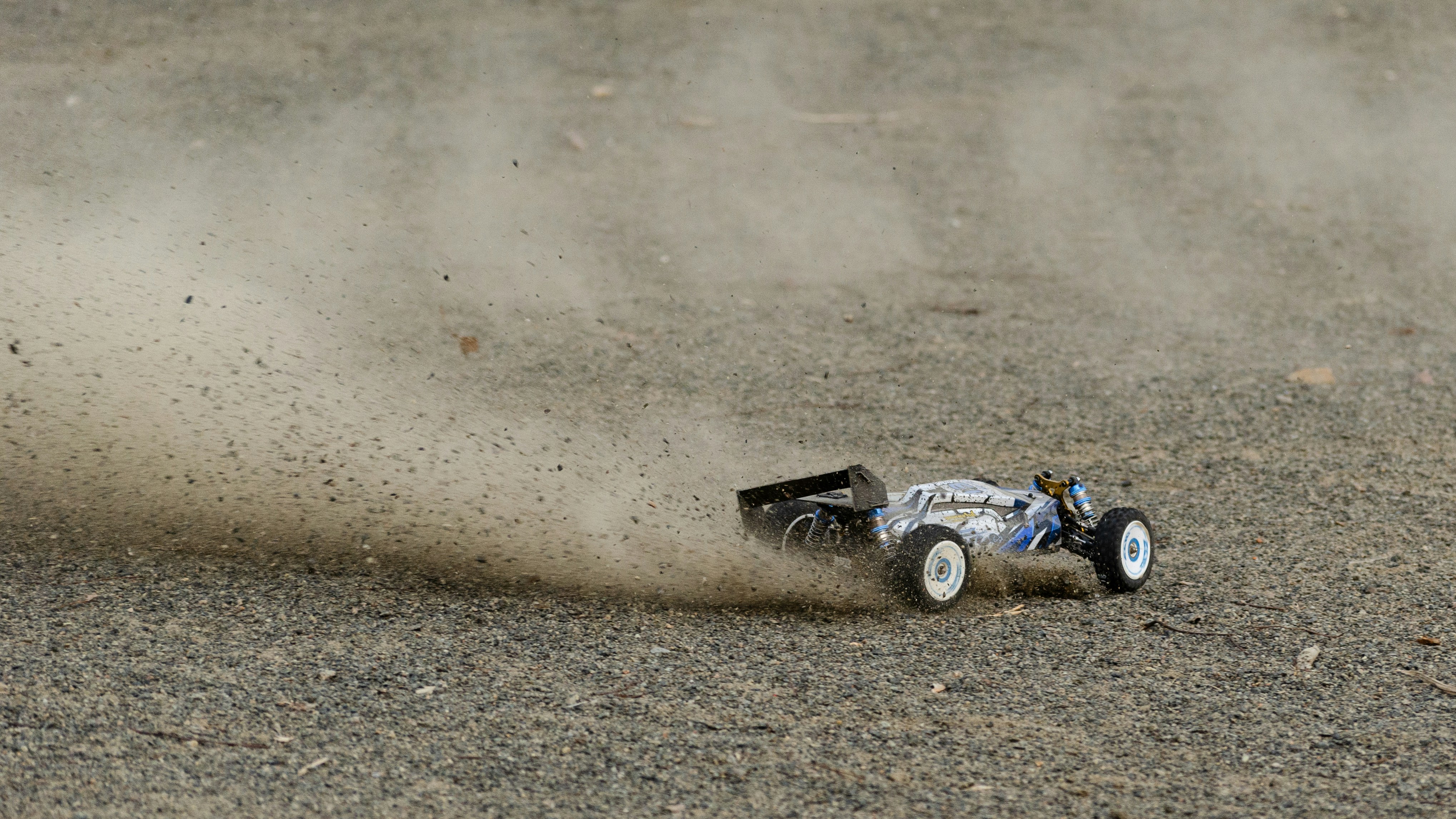 A radio controlled car is racing on dirt.