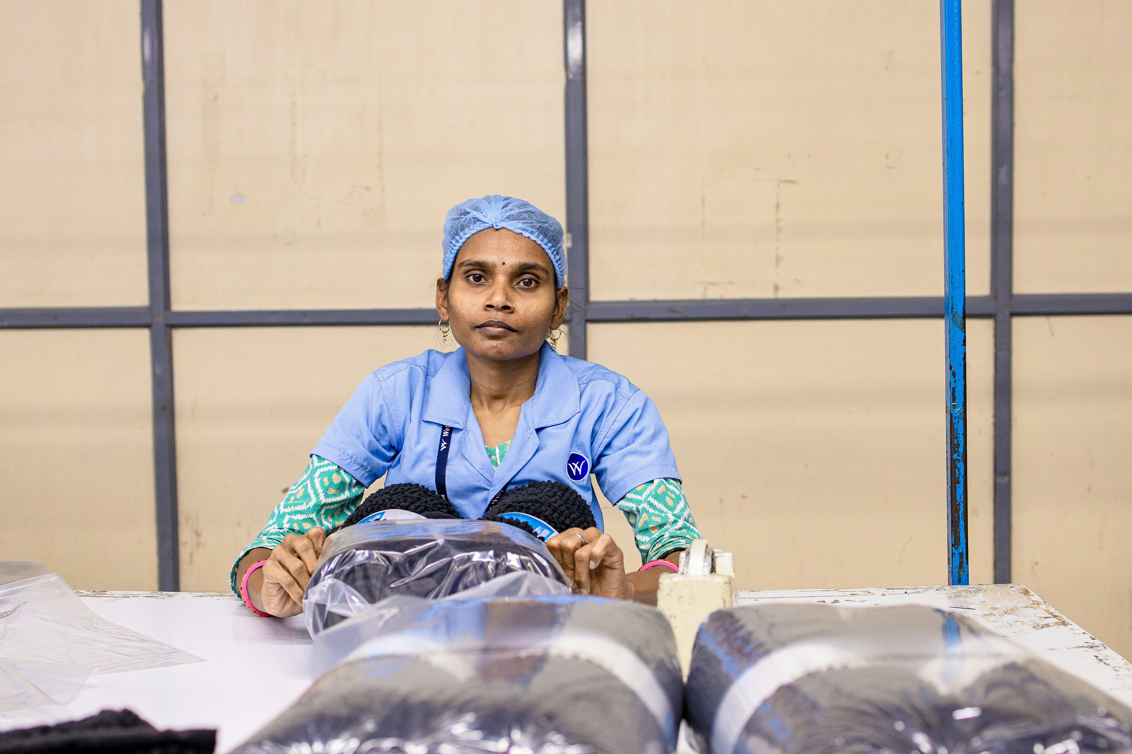 Une femme travaille avec des produits emballés dans un entrepôt.