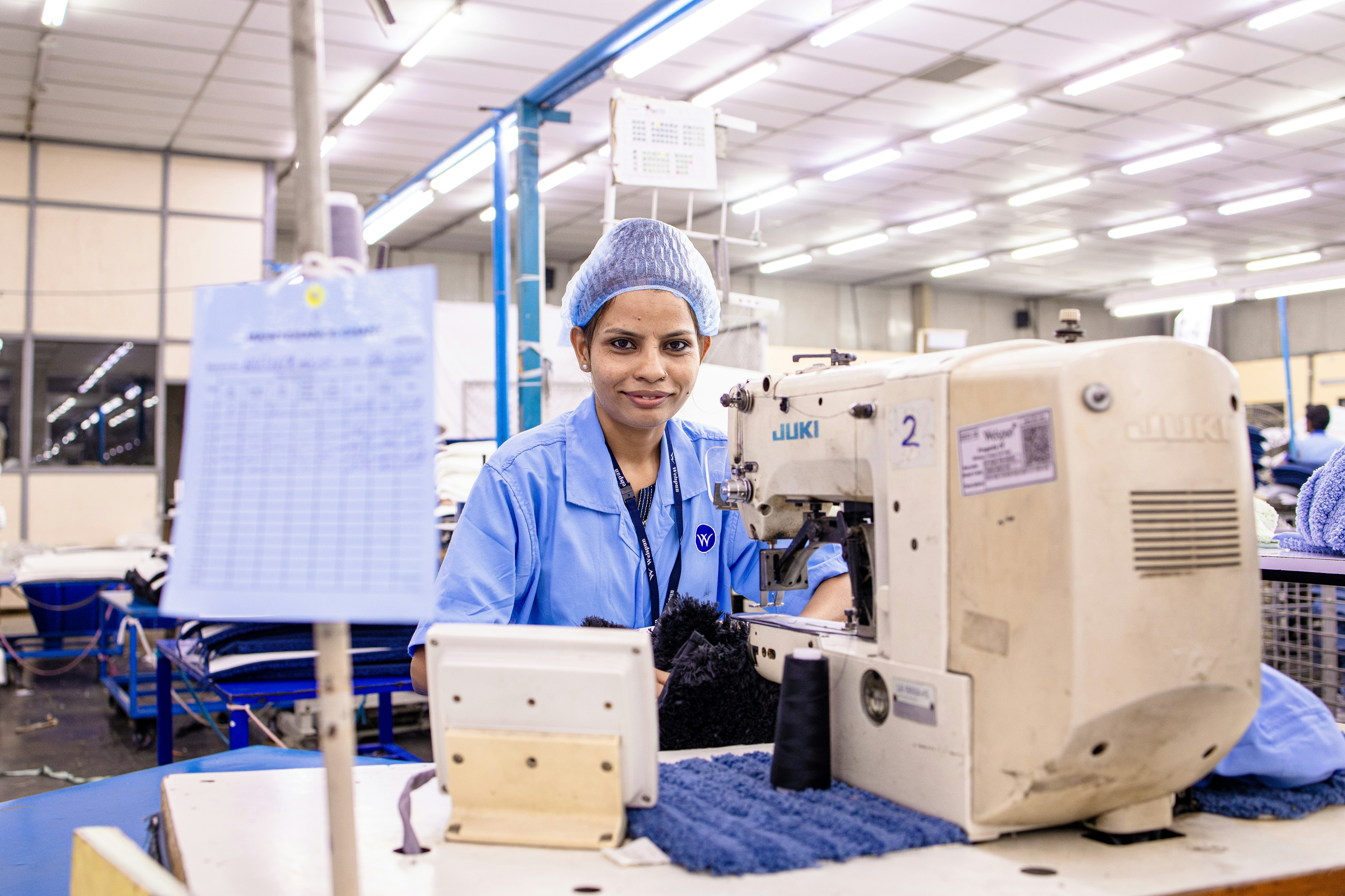 Une femme travaille sur une machine à coudre dans une usine.