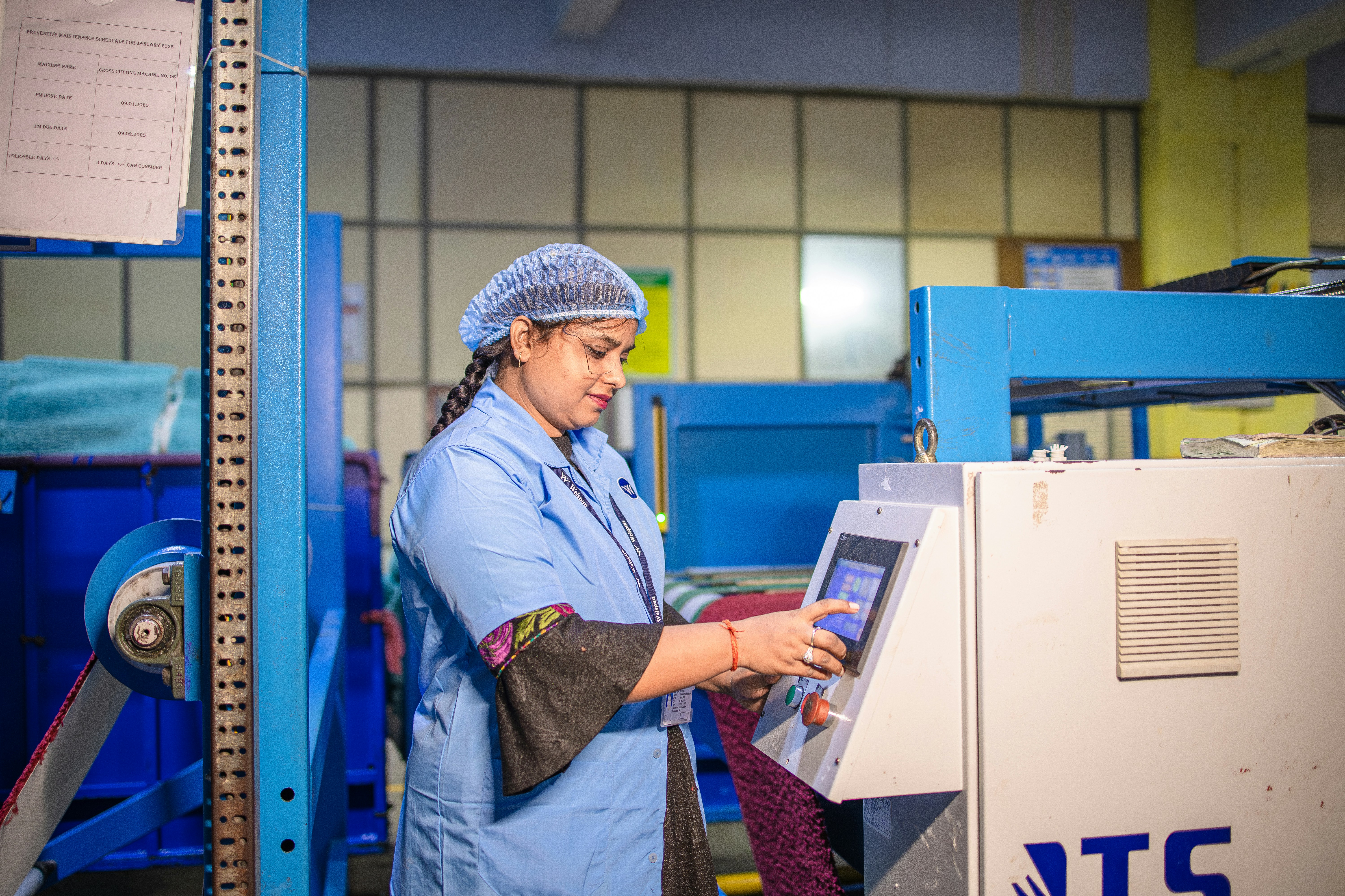 Woman operates a machine in a factory.