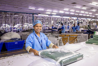 A worker packages clothing in a factory.
