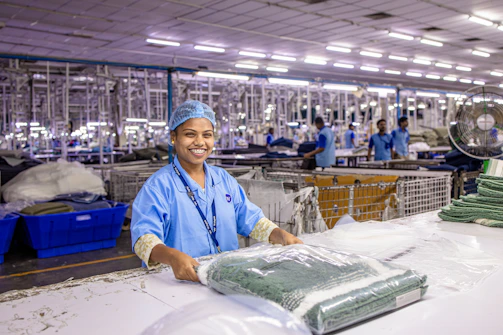 A worker packages clothing in a factory.