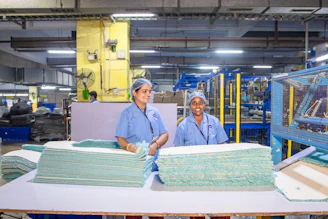 Workers are in a textile factory, processing materials.