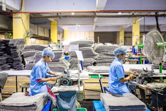 Workers operate machinery in a factory environment.