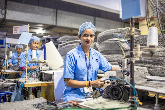 Workers operate machinery in a factory setting.