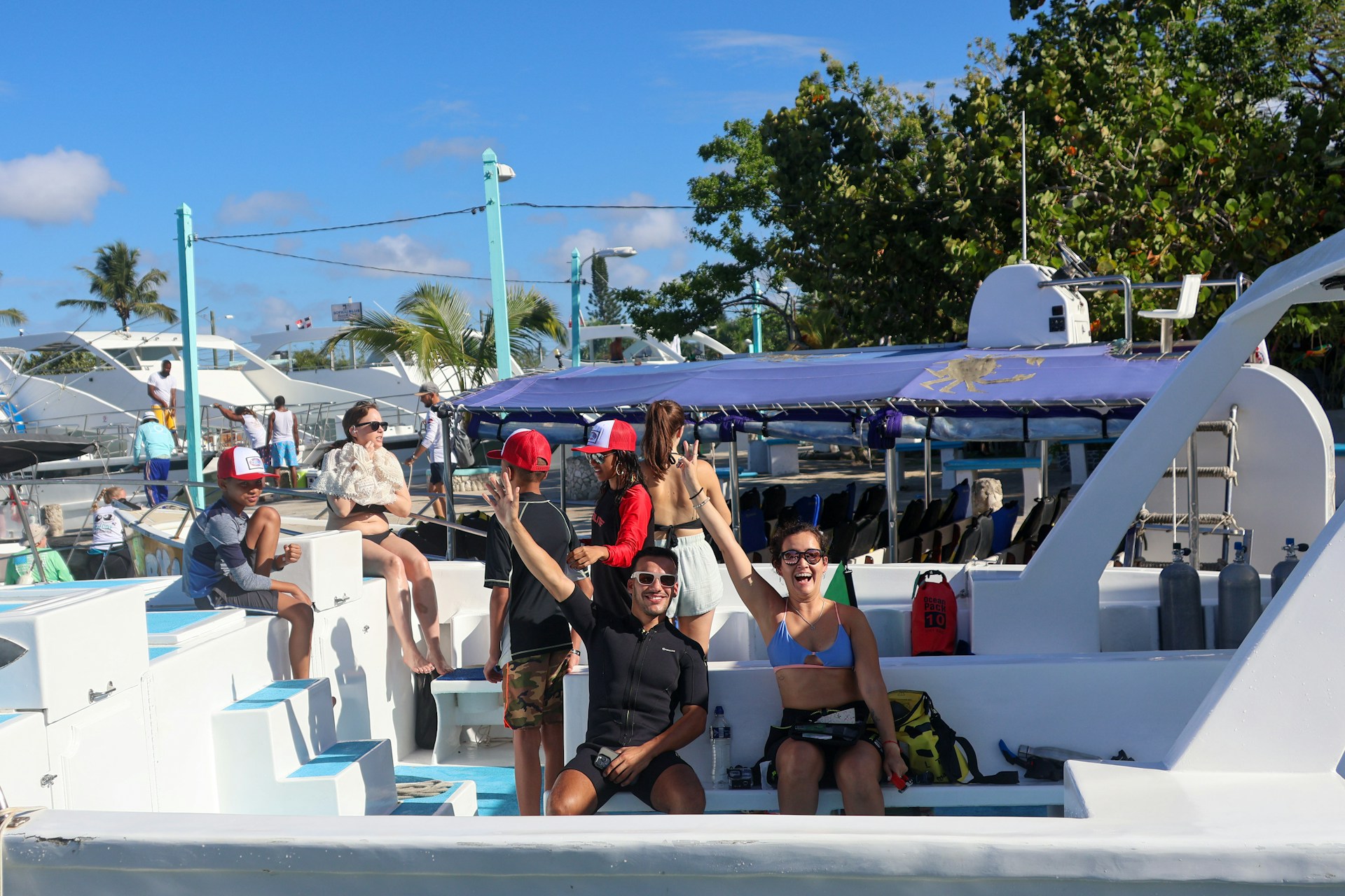 Group of people posing on a boat, sunny day.