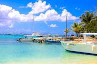 Boats are docked on a beautiful, sunny beach.