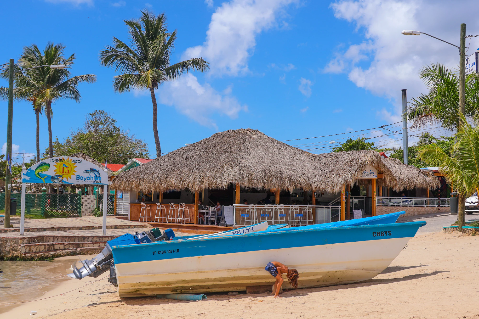 Playa caribeña con un bar de playa y un bote bajo el sol