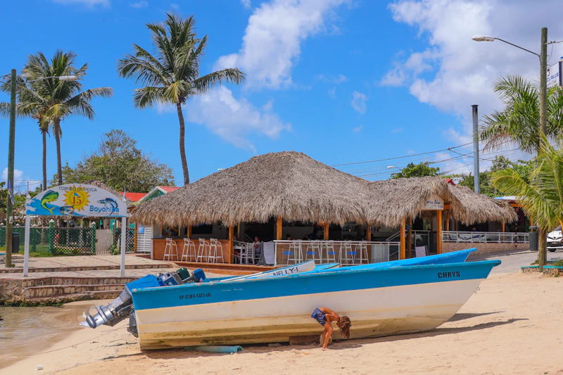Playa caribeña con un bar de playa y un bote bajo el sol