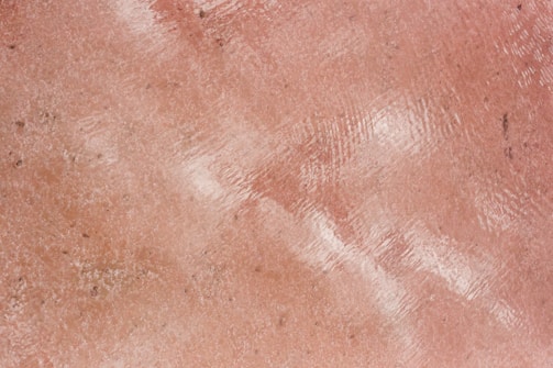 Textured pink surface with a reflective shine.