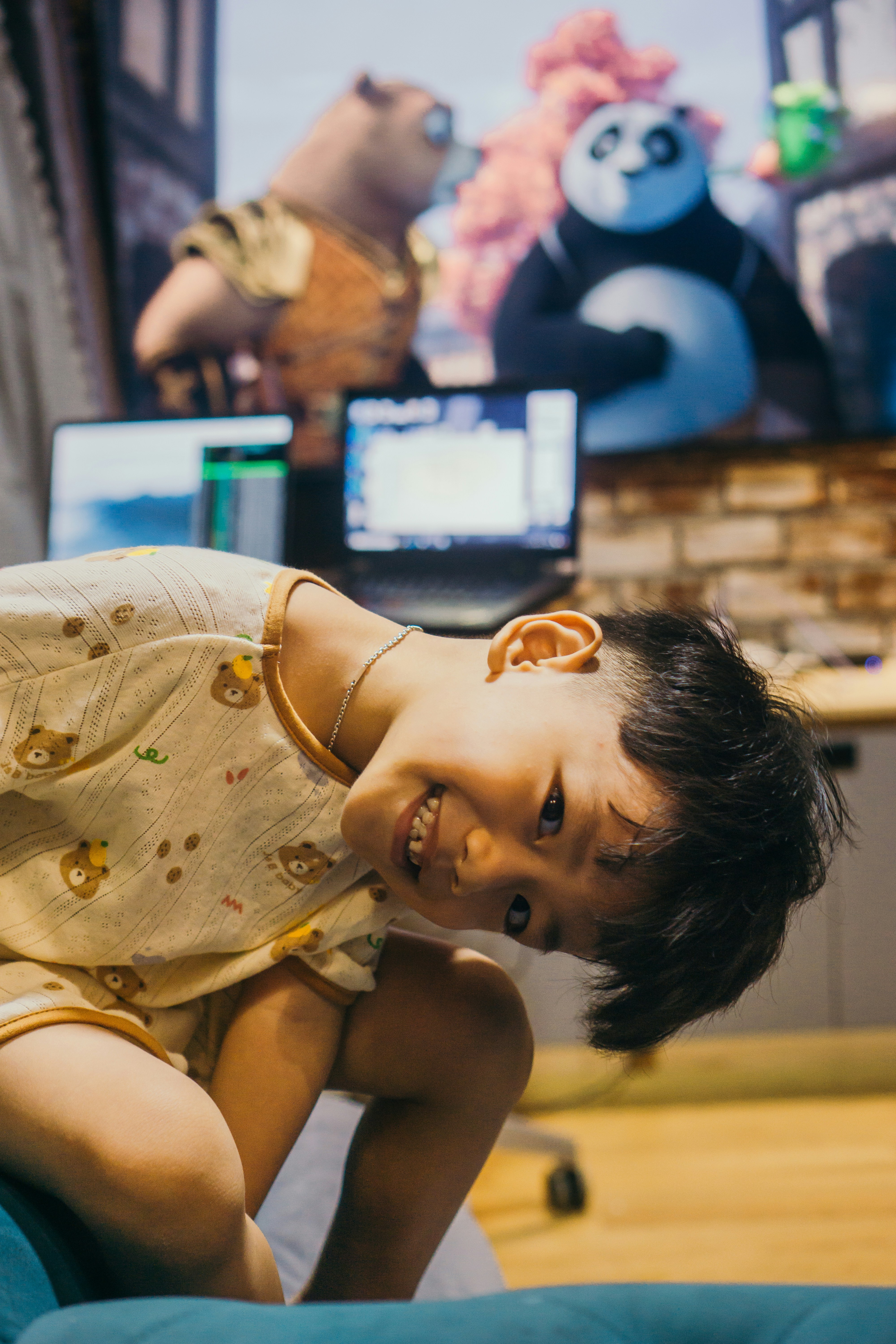 A smiling boy watches kung fu panda.