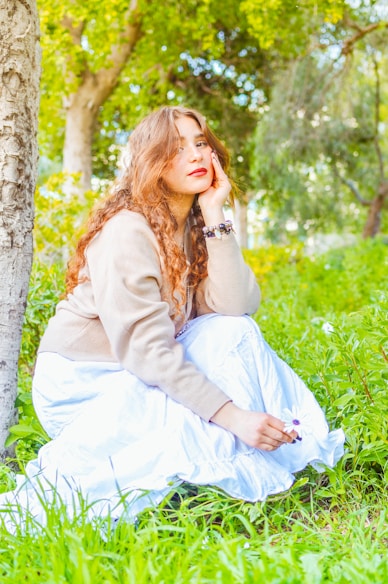 Beautiful woman sits among nature, contemplating.