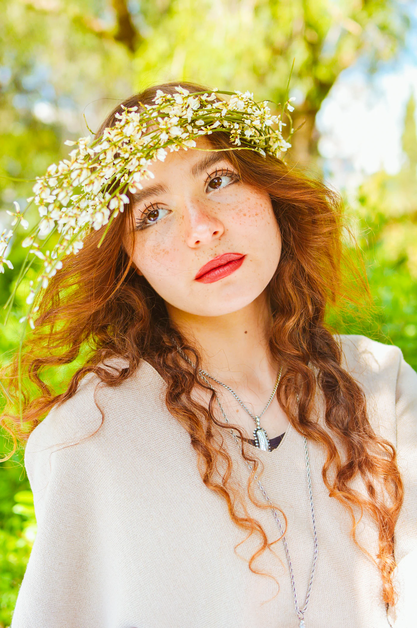 DIY flower crowns for bridesmaids — A group of bridesmaids with matching floral crowns smile during an outdoor wedding photo session.