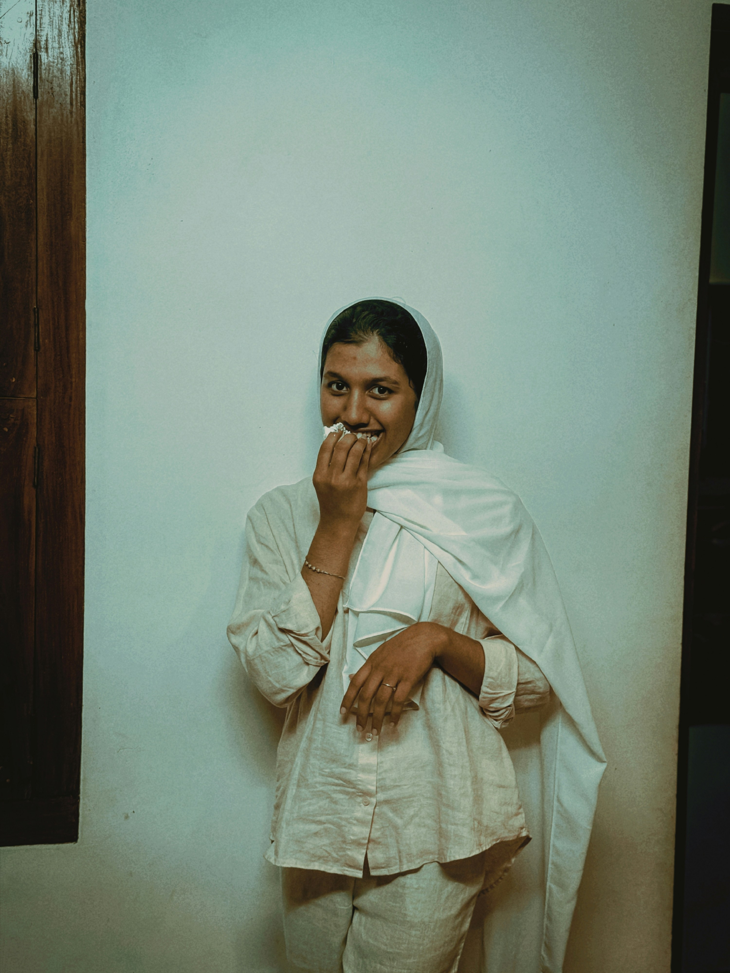 Donna sorridente in abiti bianchi posa per una foto.