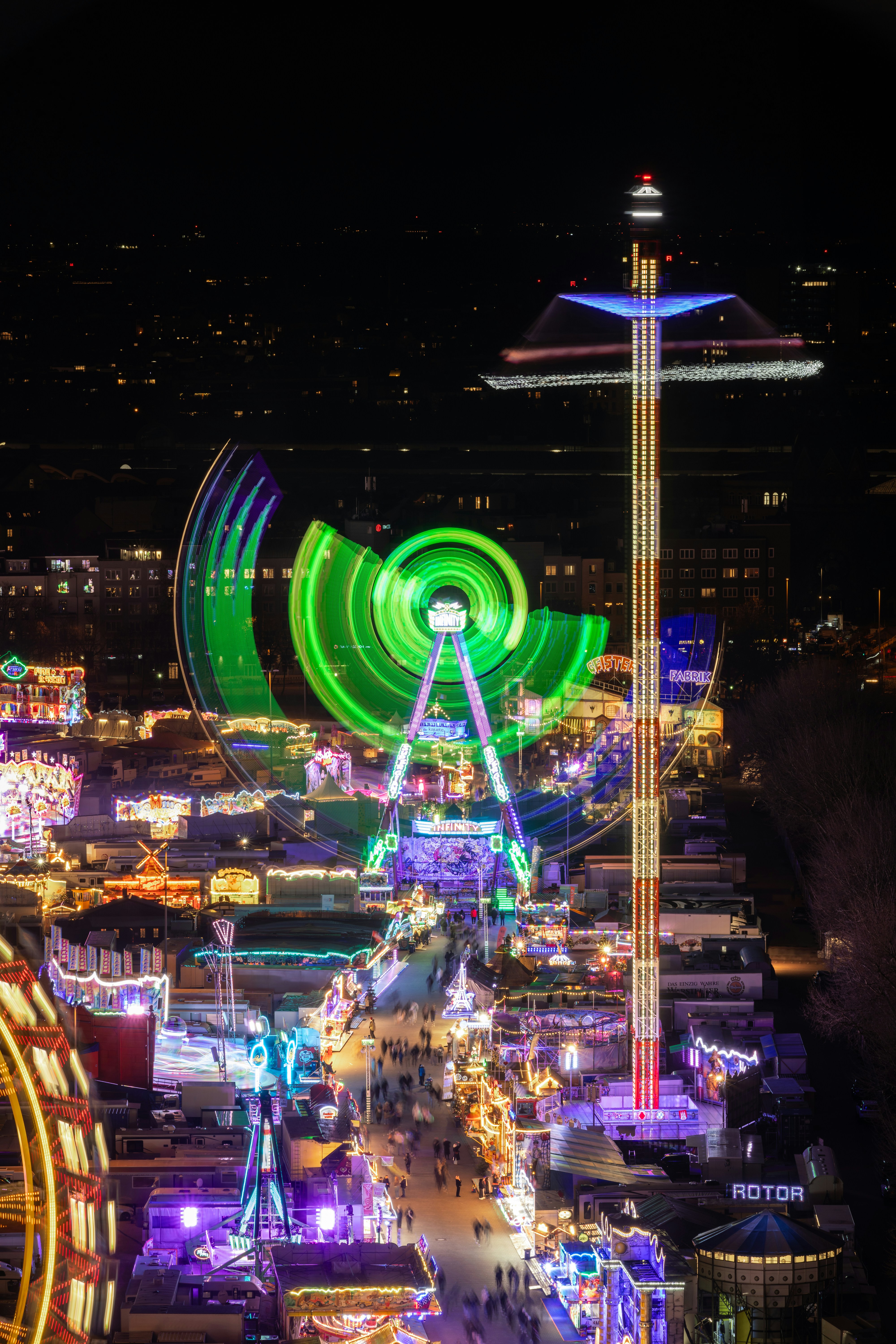 A night carnival glows with amusement park rides.
