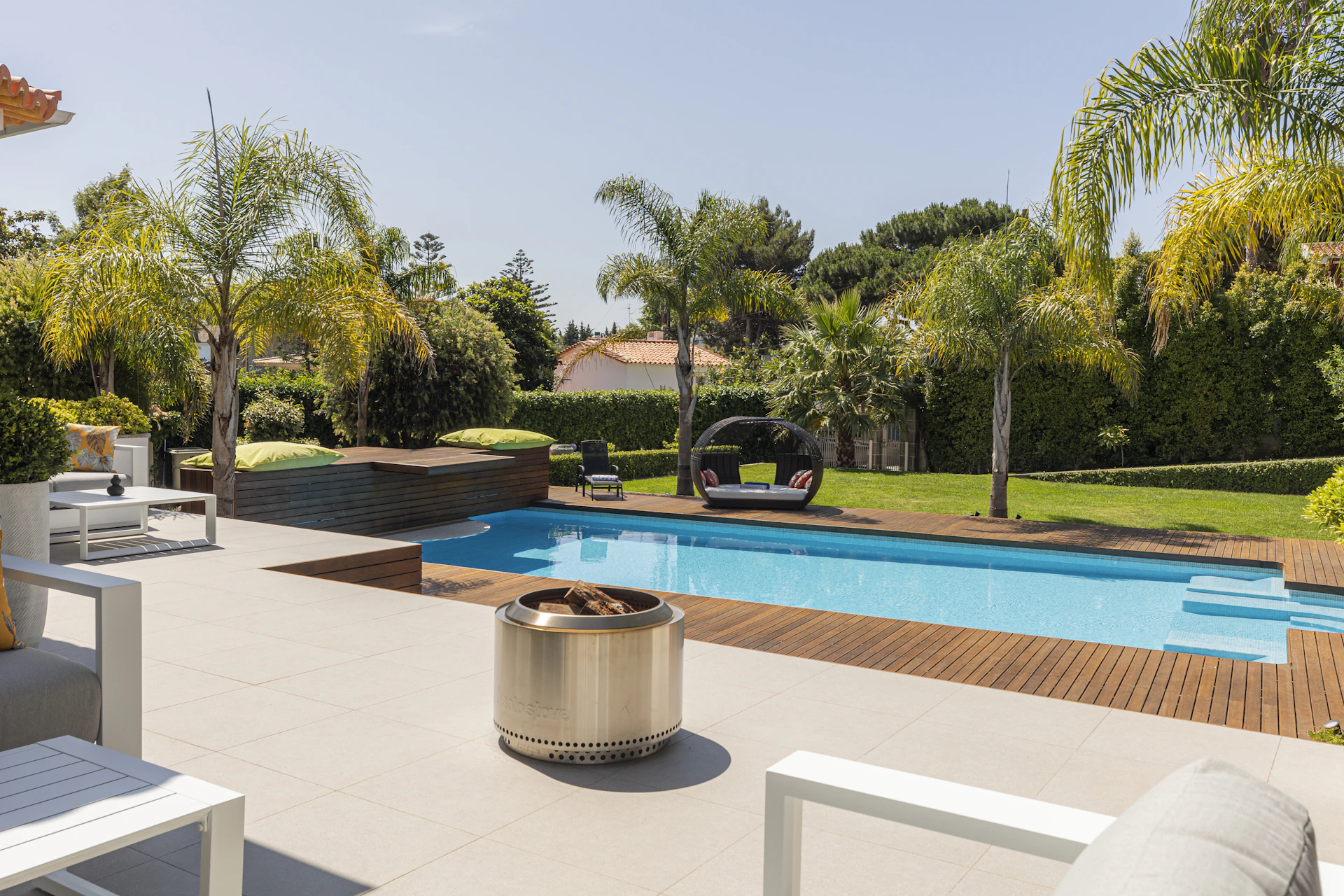 A luxurious backyard with pool under sunny skies.
