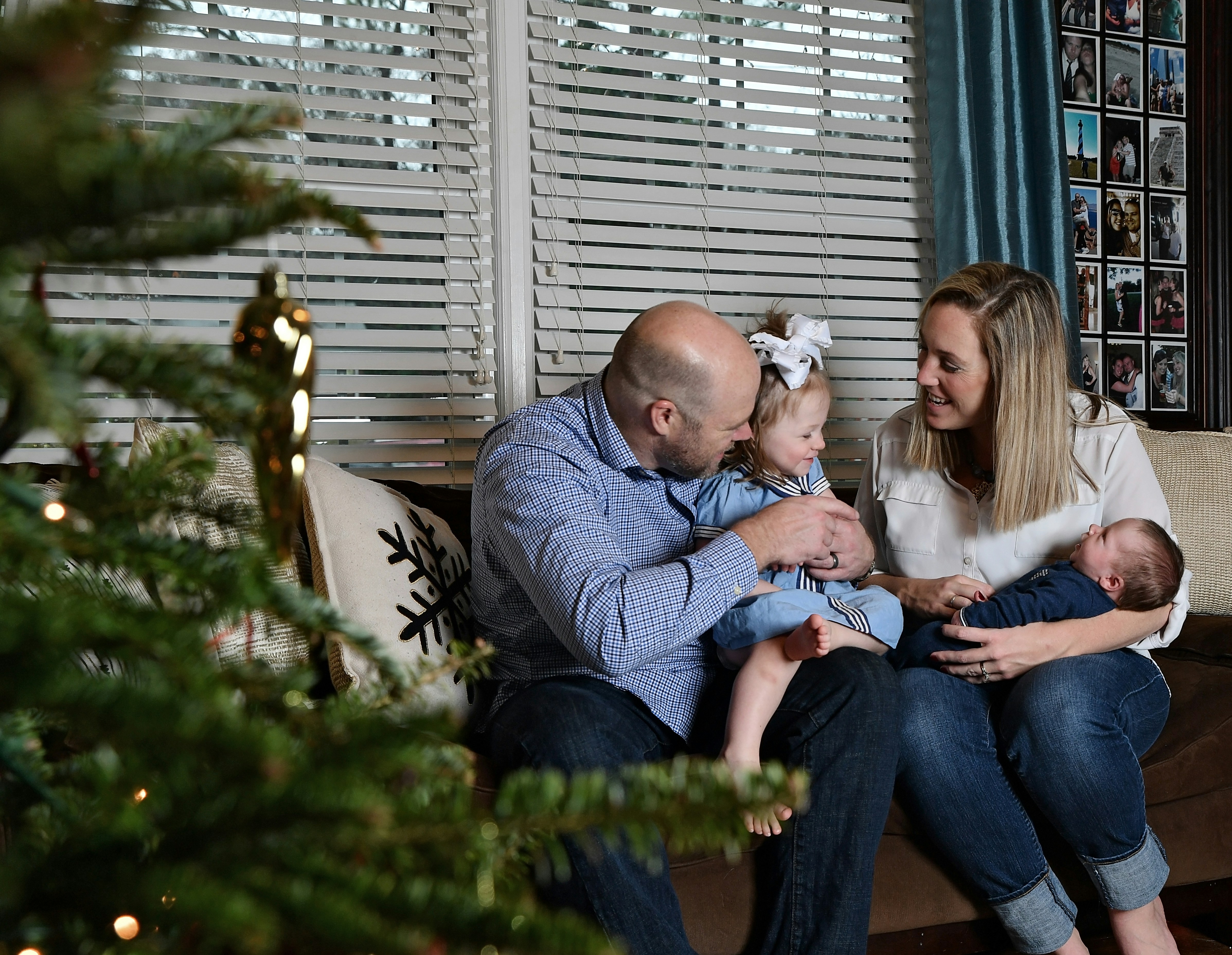 Family posing together for a Christmas photo in a warm, softly lit living room