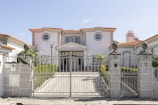 A luxurious mansion with a large front gate.