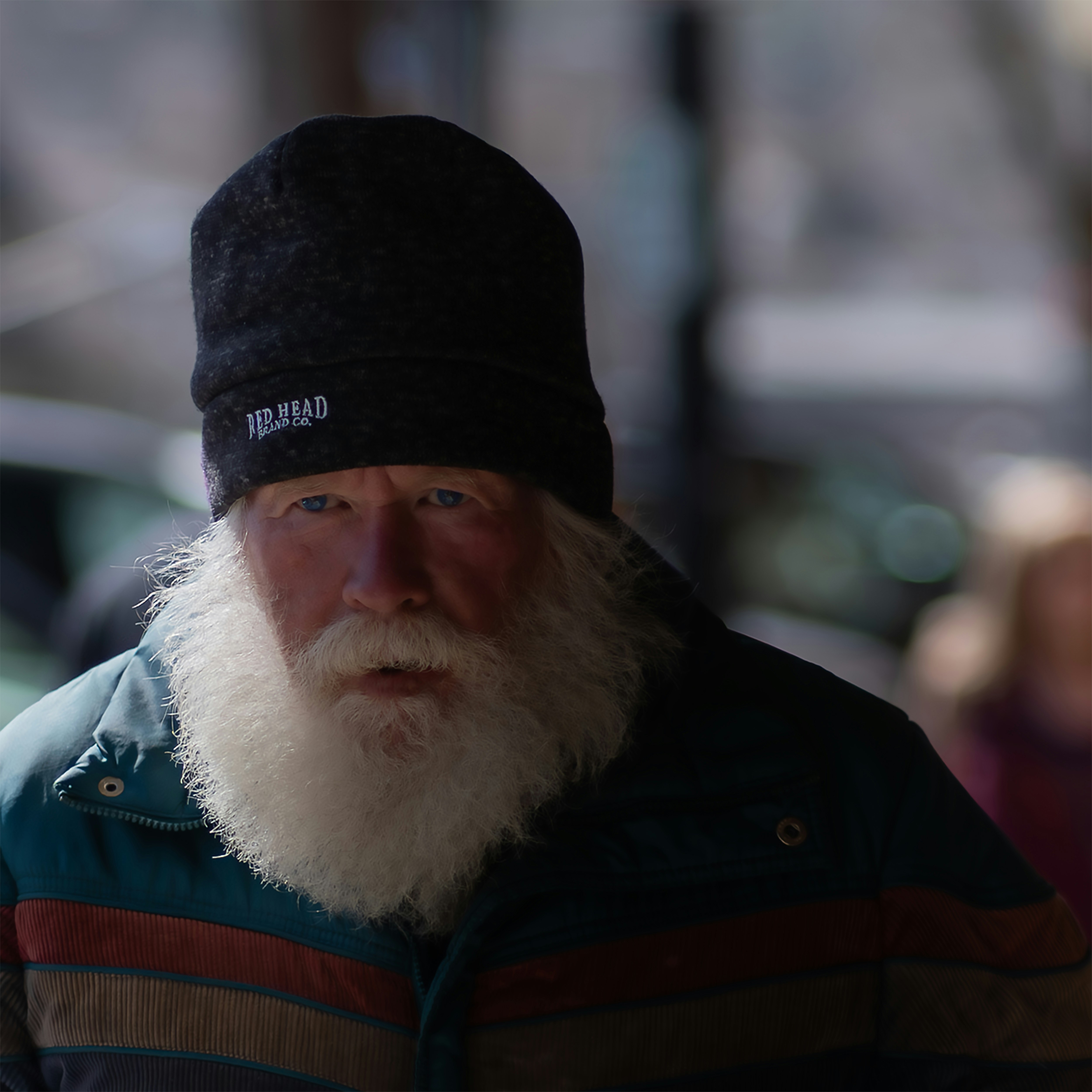A man with a white beard and black hat.