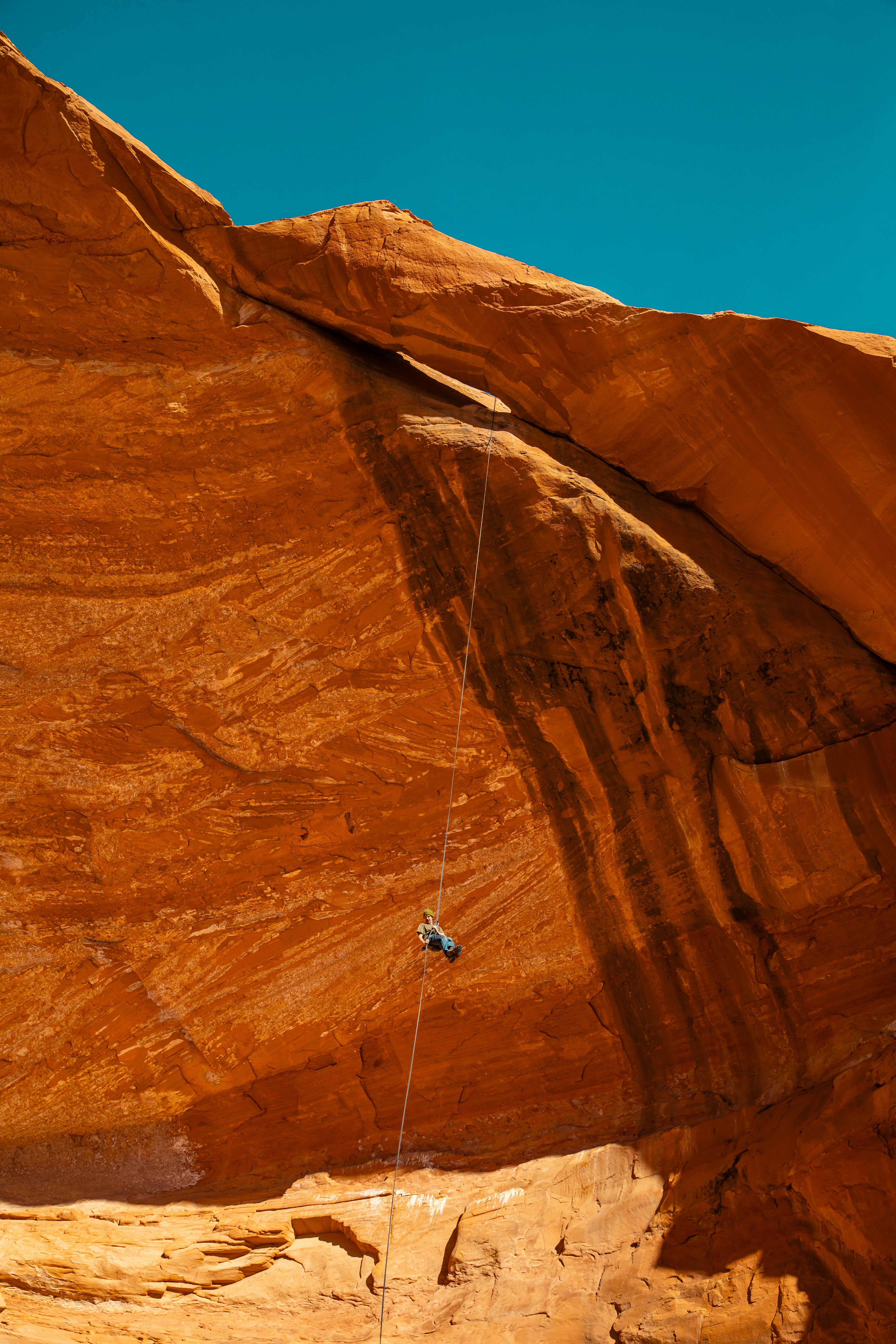 A rock climber rappels down a cliff.