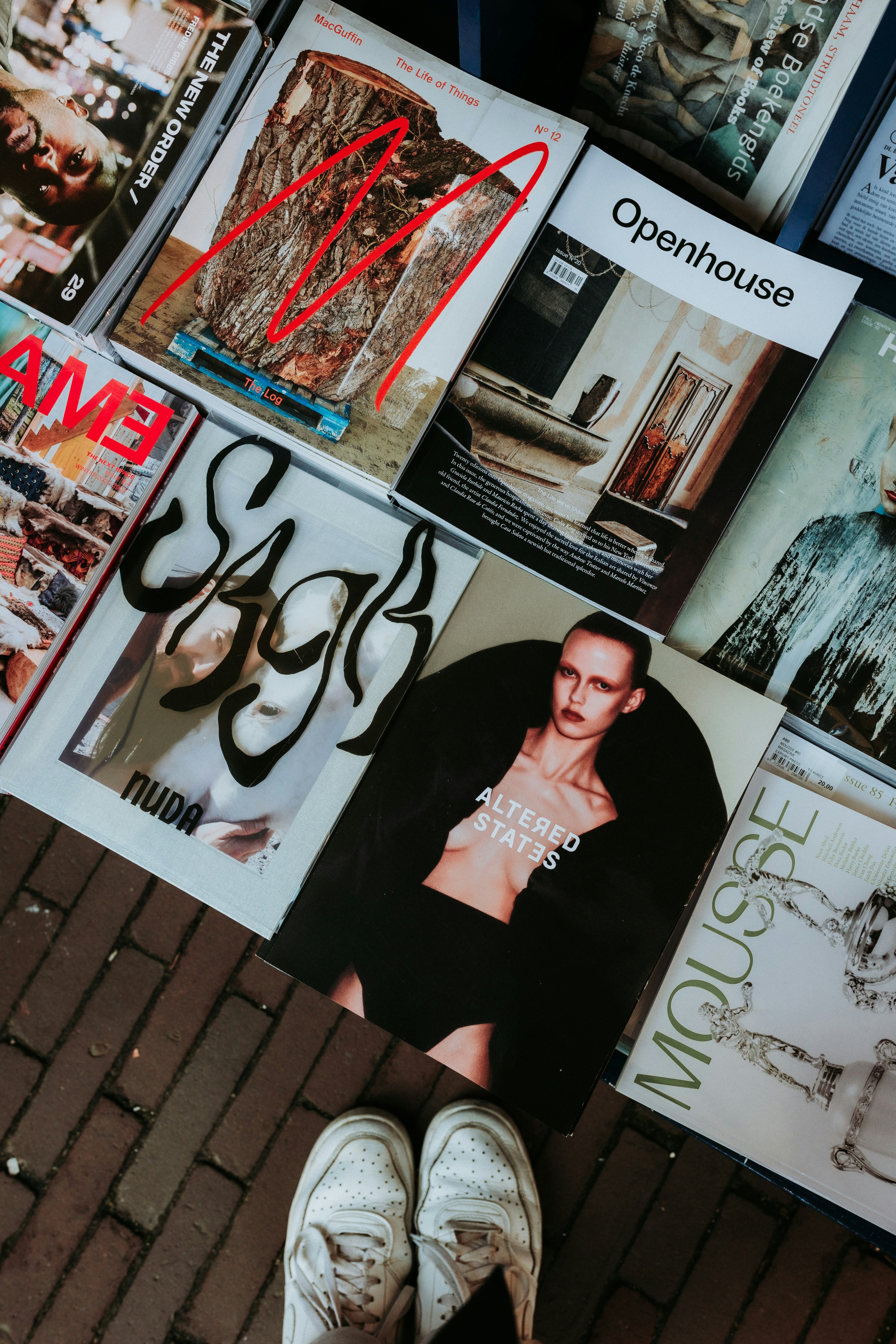 Magazines are displayed with a person's feet.