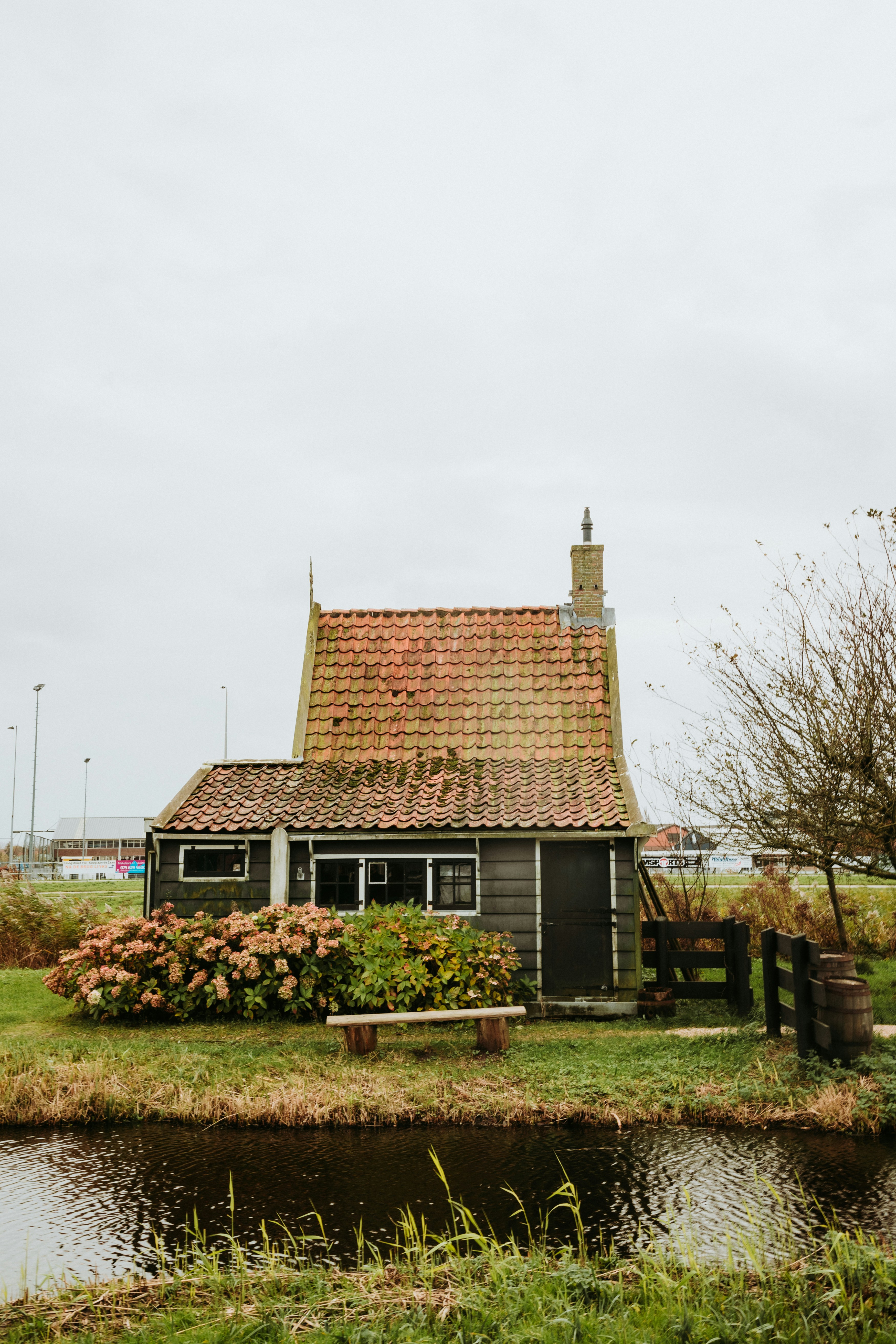 A cozy cottage sits beside a small canal.