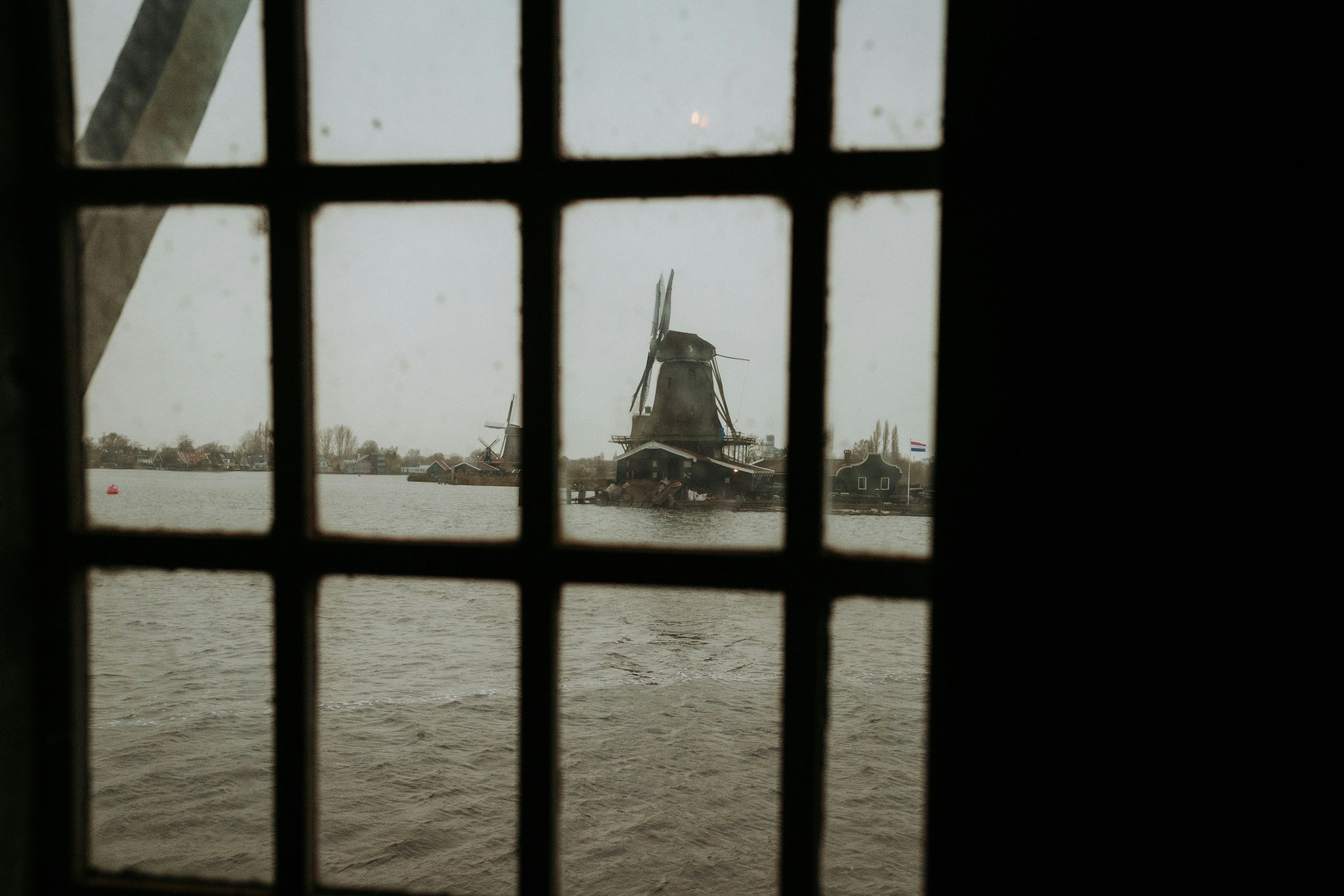 View of windmills framed through a window.