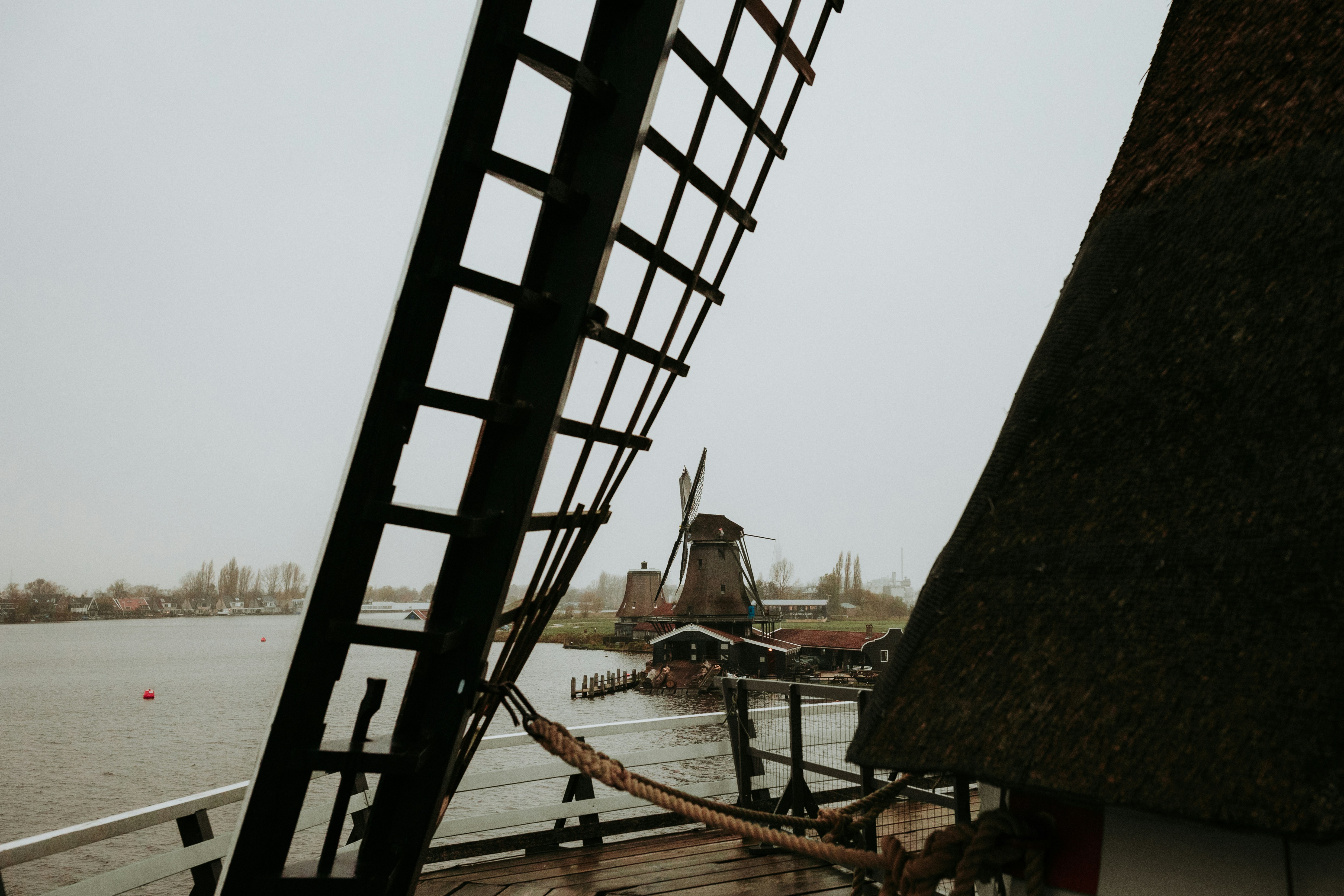 Windmills and water under a gray sky.