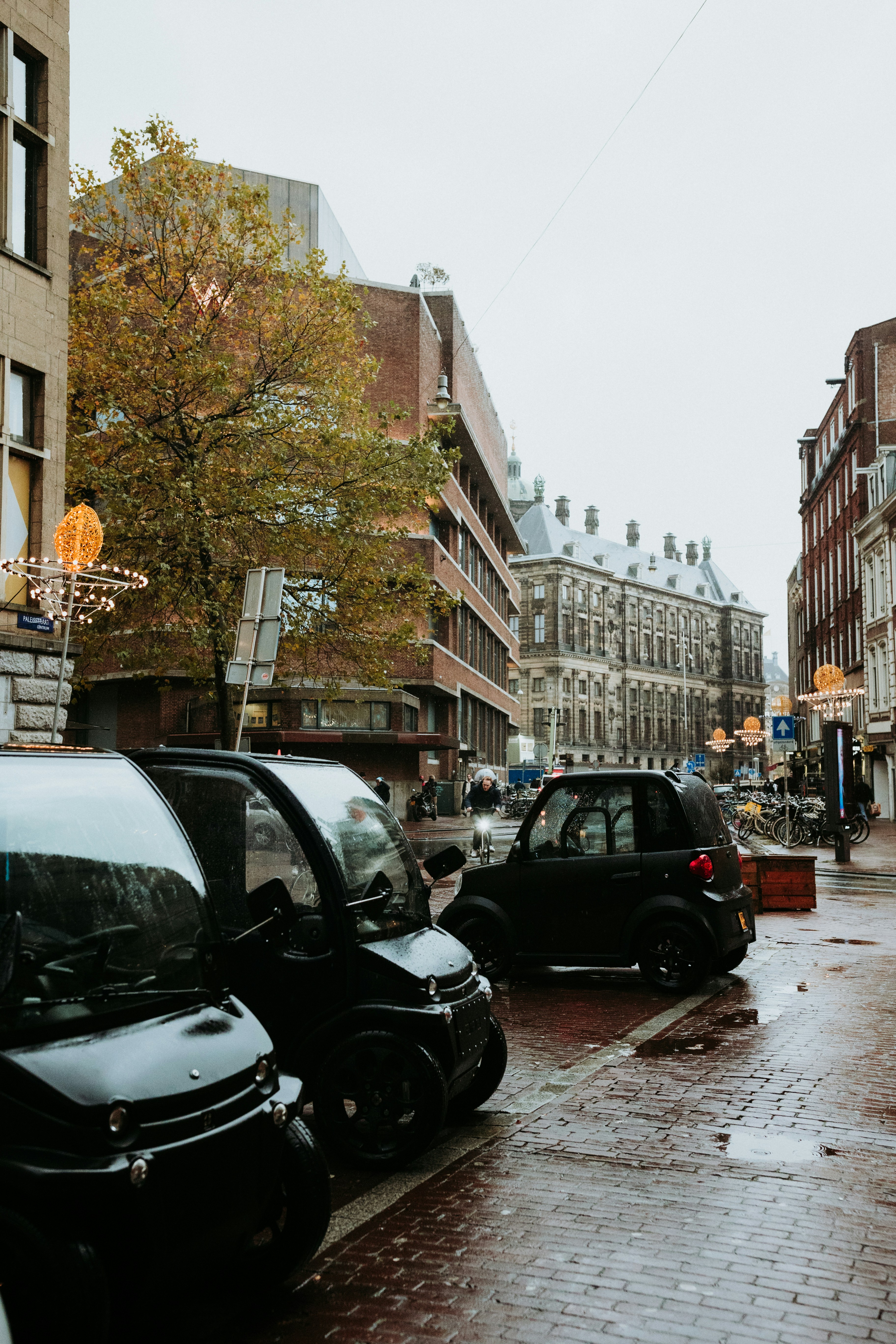 Cars are parked on a wet city street.