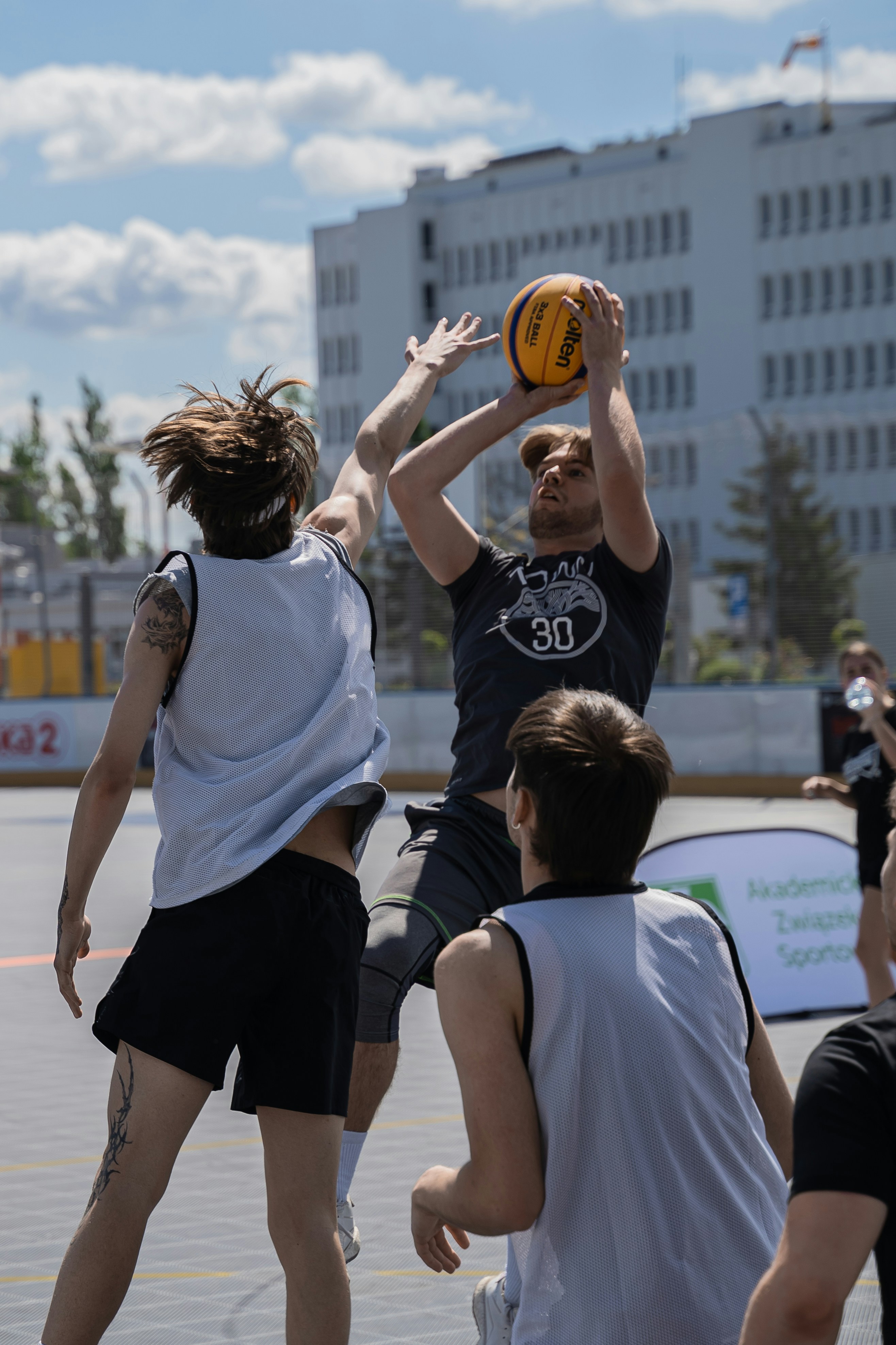 Basketball players competing in a game outside.
